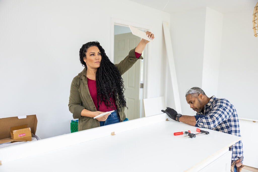 As seen on Married to Real Estate, hosts Mike Jackson and Egypt Sherrod work together to finish cabinets and design elements in a completely renovated kitchen for a homeowner.