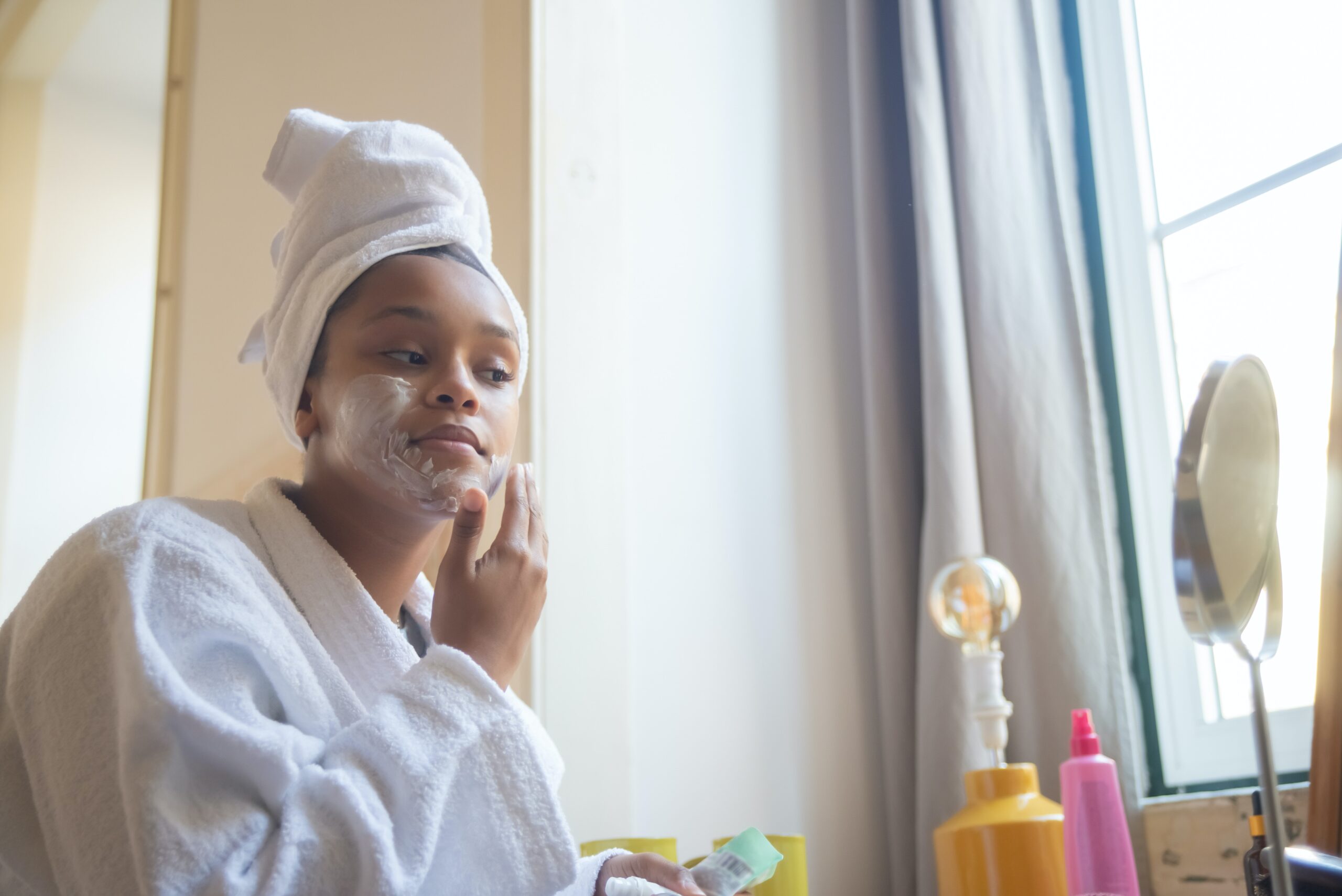 woman applying face mask at home spa