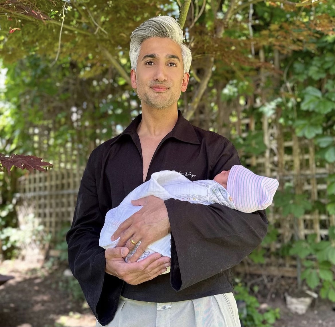 Tan France holding his newborn son