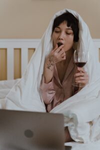 Woman drinking wine and watching a movie; staycation ideas