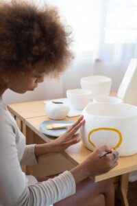 a woman painting a pot 