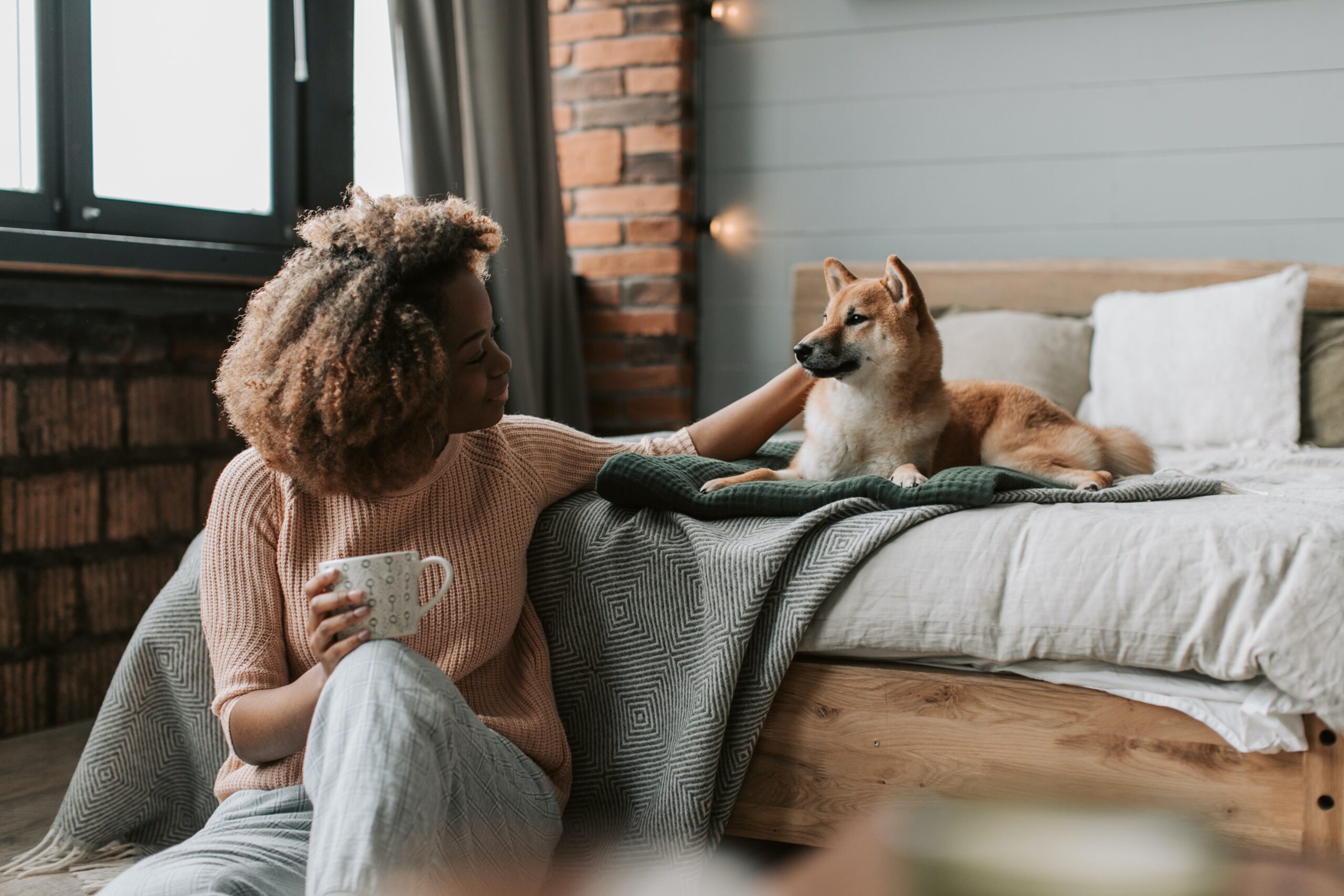 Woman in a relaxing bedroom with her dog
