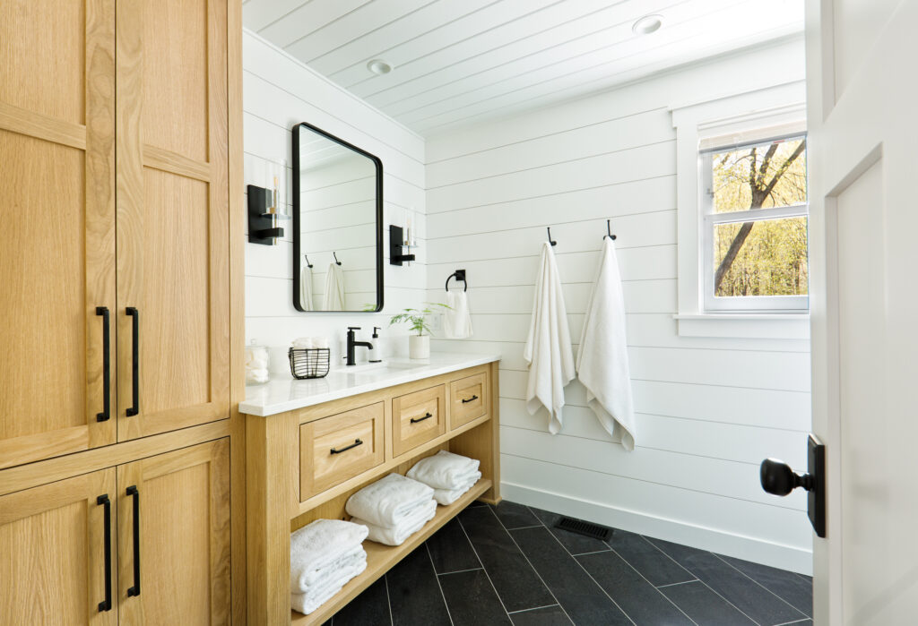 A contemporary modern bathroom design for a country home cabin. featuring a classic freestanding vanity and linen storage cabinet.