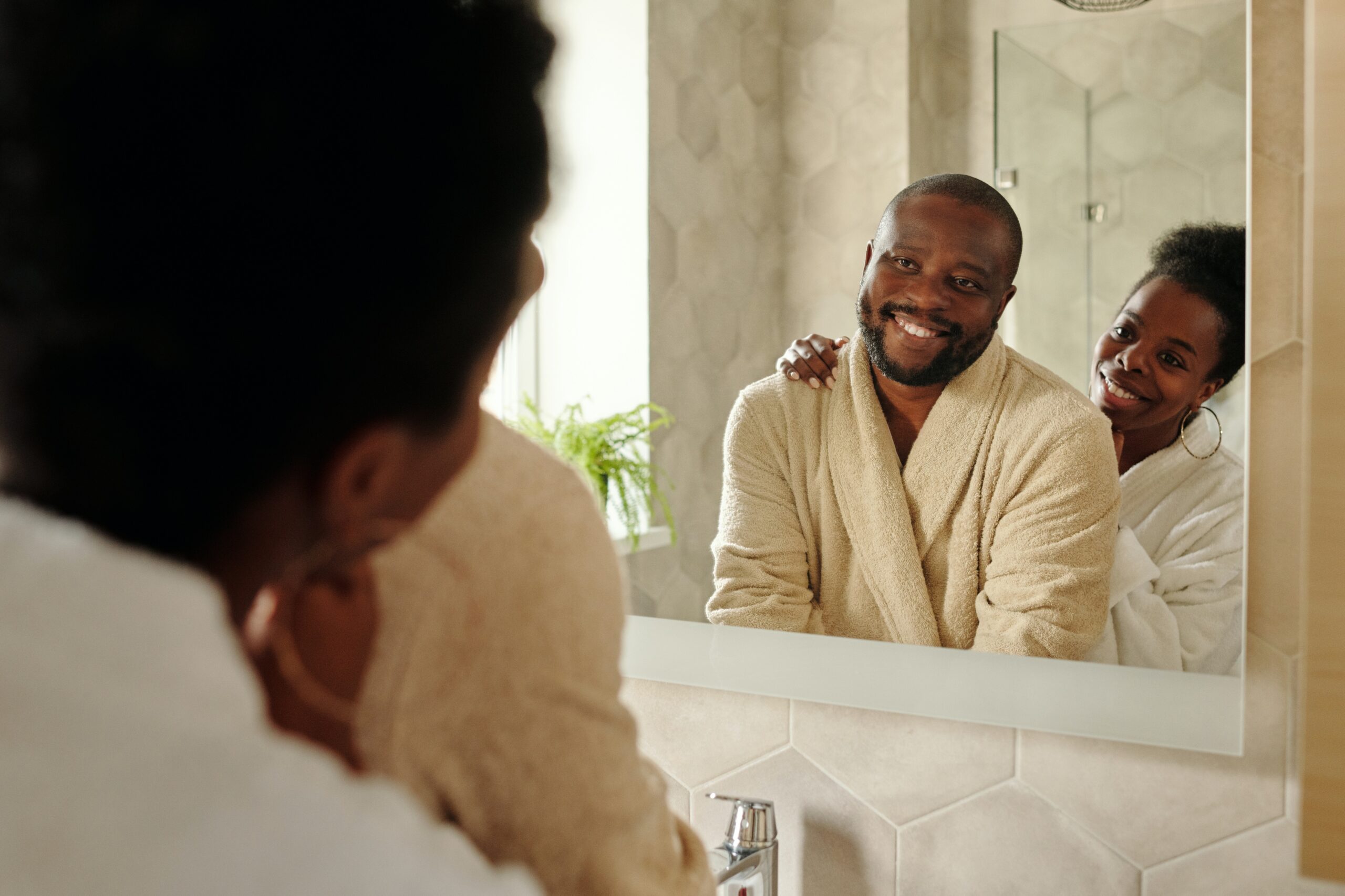 A man and woman smiling at each other in the mirror