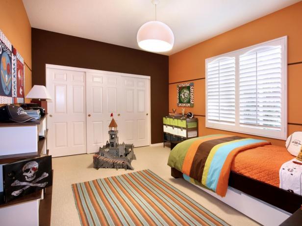 For a rustic look, orange is one of the best paint colors for bedrooms. Pictured: A bedroom painted orange with decor.