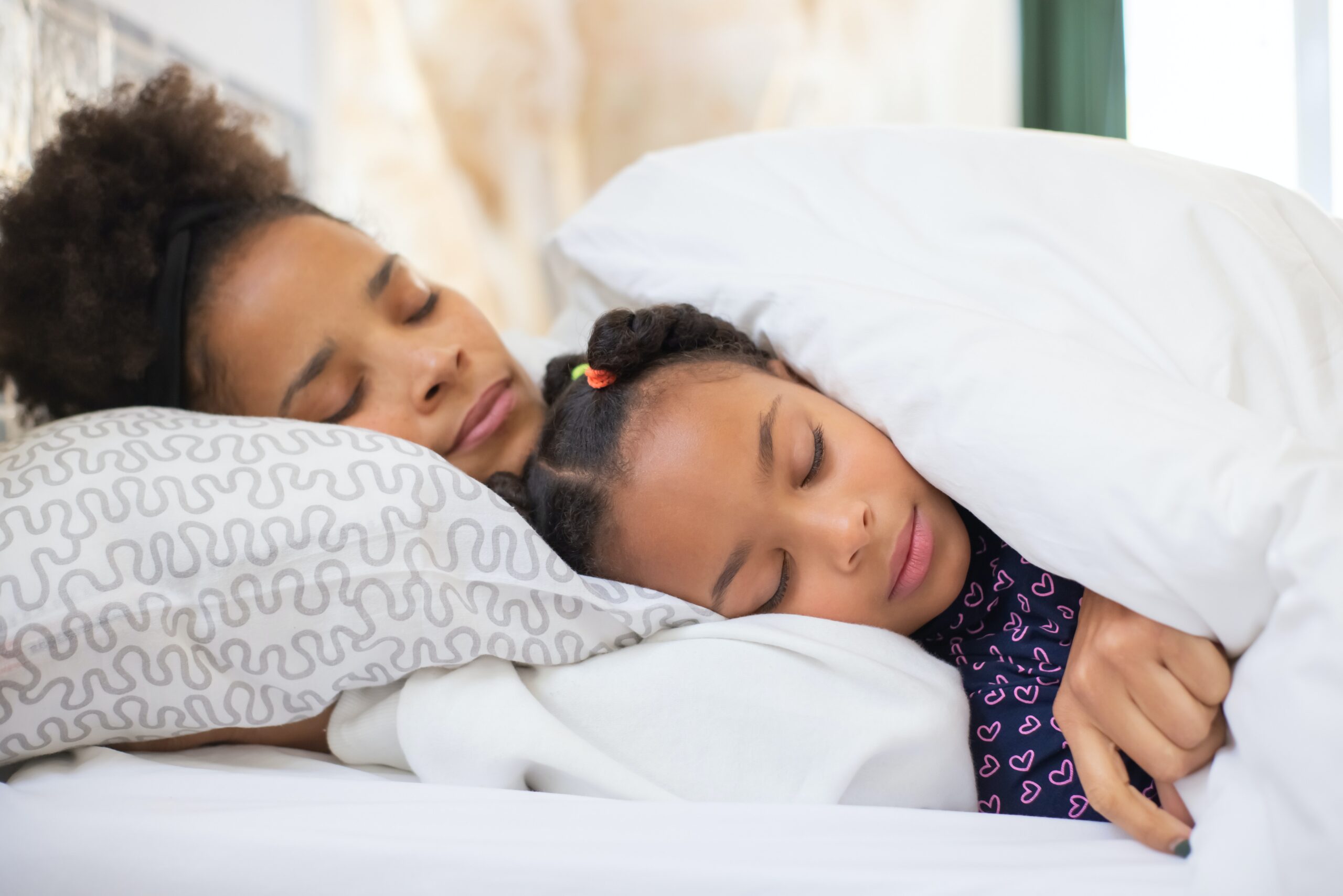 mother and daughter on high-quality mattress