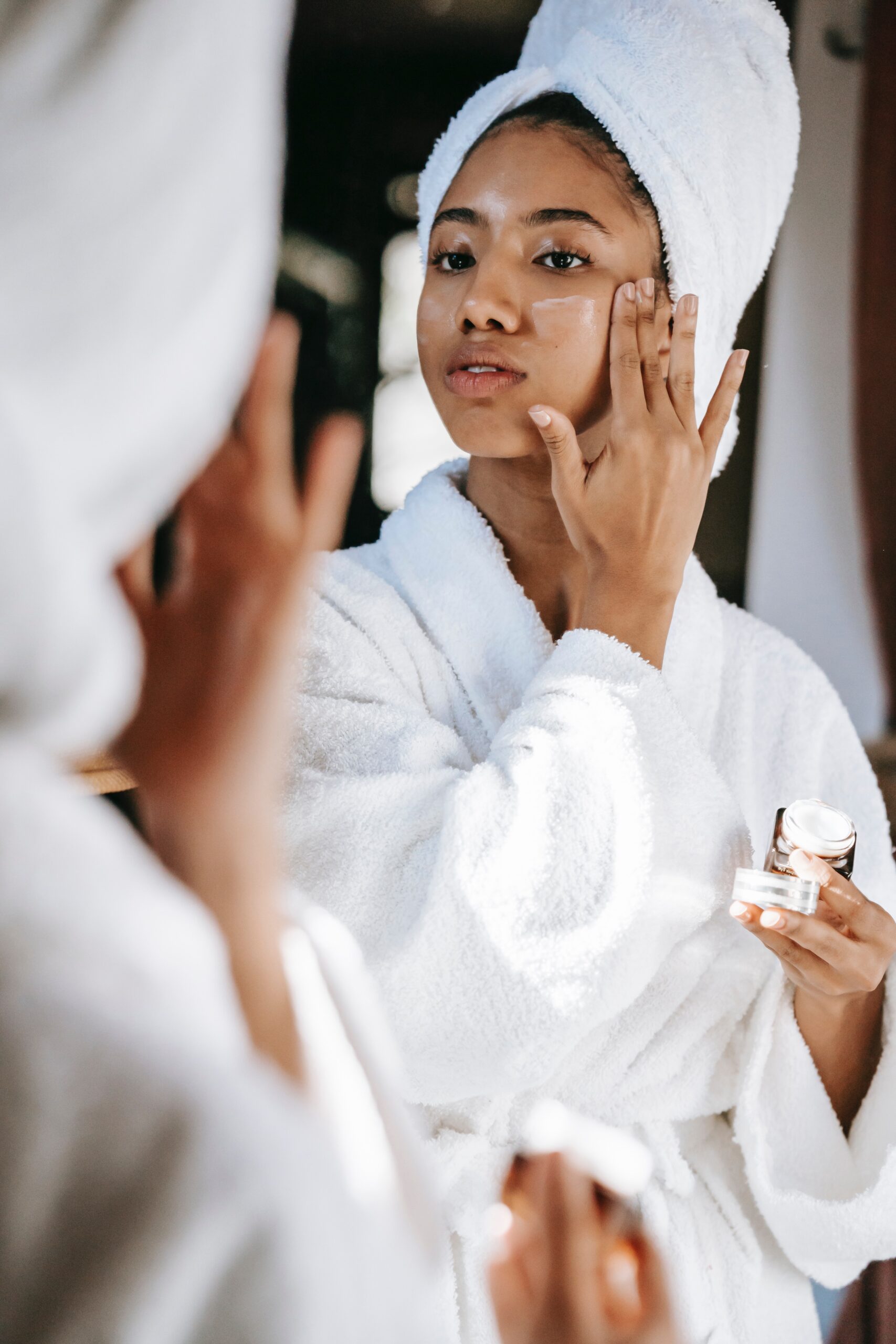 Woman applying skin care in robe