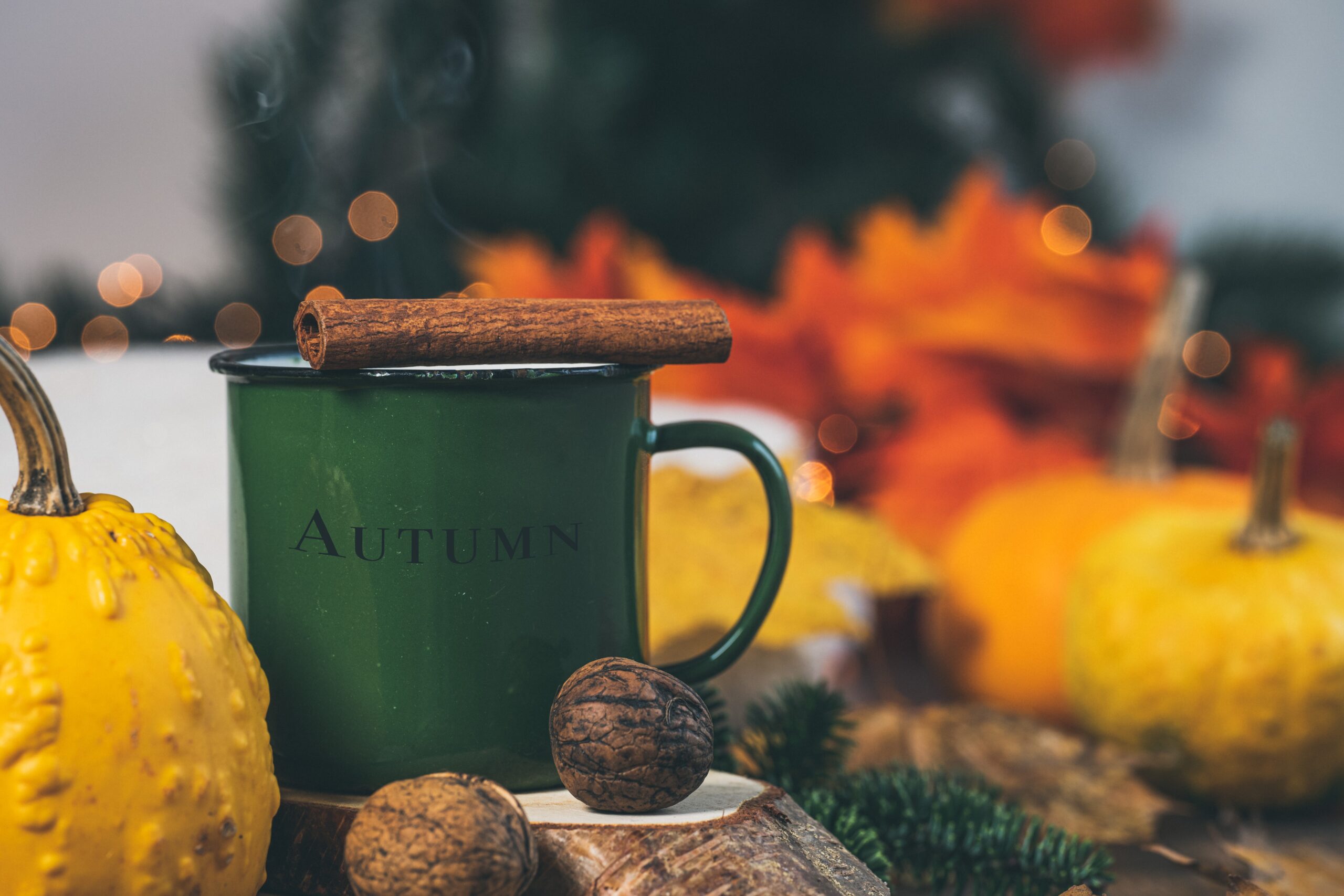 Olive green decorations to include in your deep autumn color palette. Pictured: An olive green autumn mug with fall decorations.