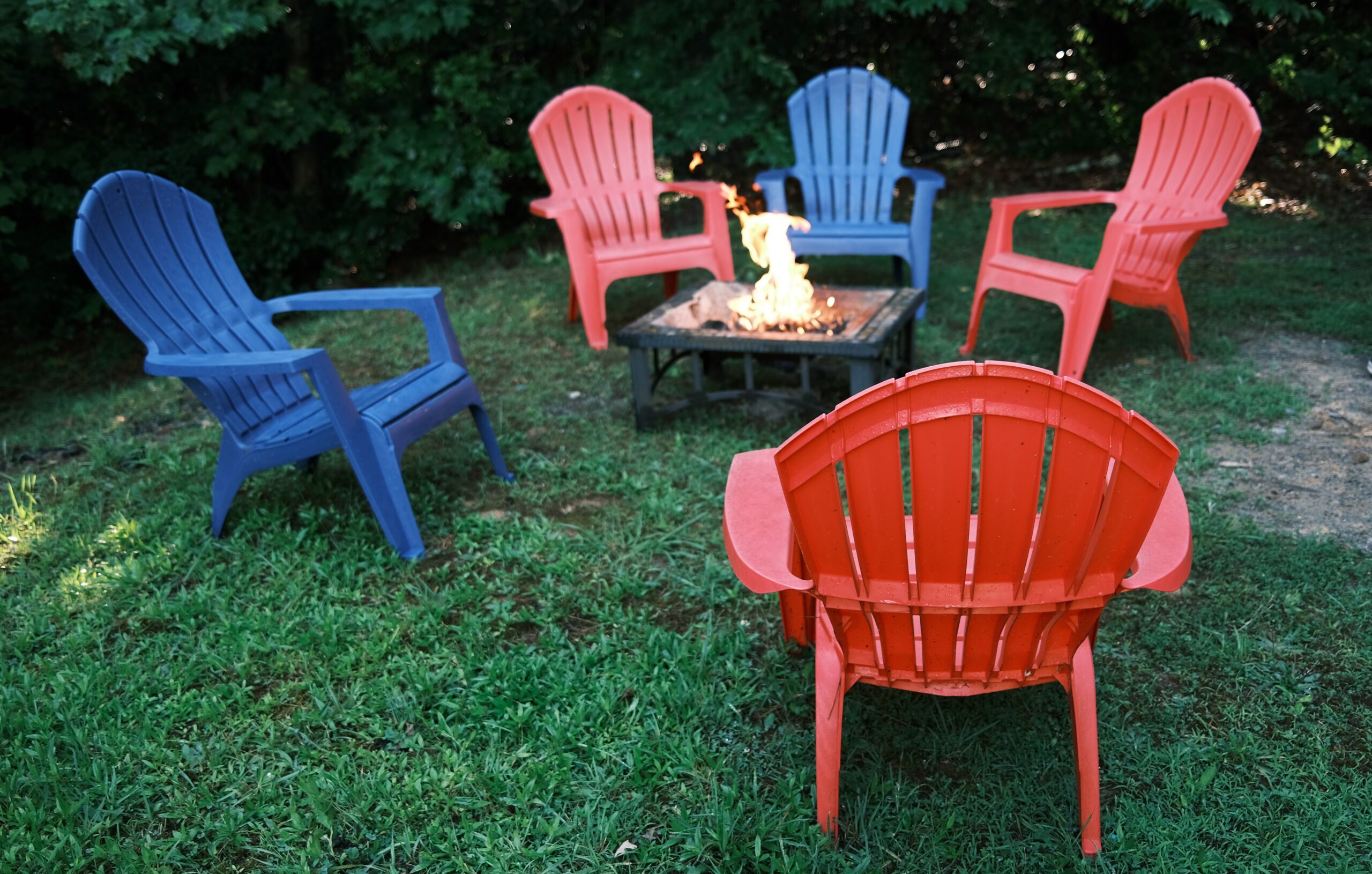 Gather around the fire for some cozy conversation. This fire pit table makes a great backyard fire pit idea. Pictured: Chairs around a table fire pit.