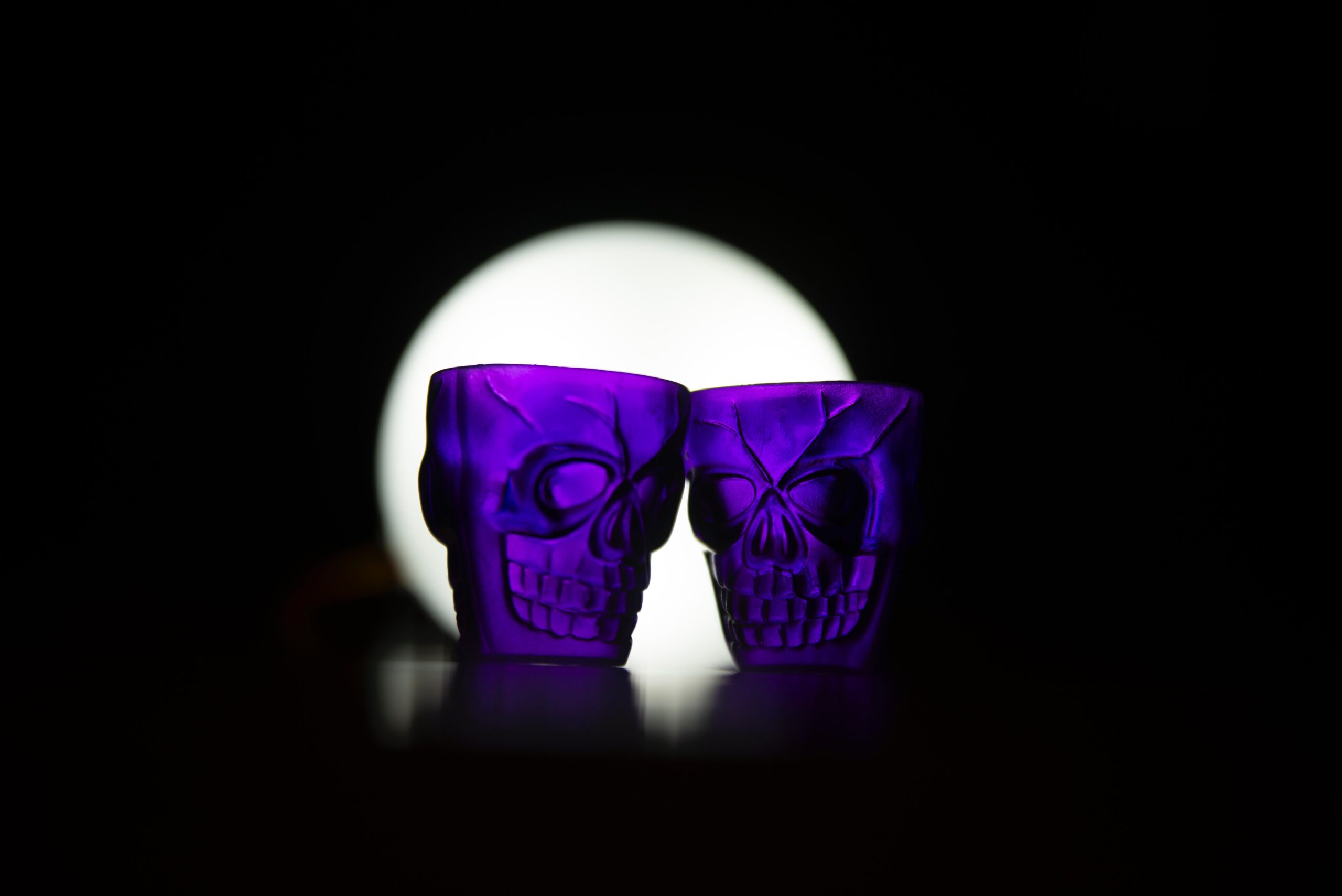 Two purple skull-shaped glasses for a creepy cocktail party
