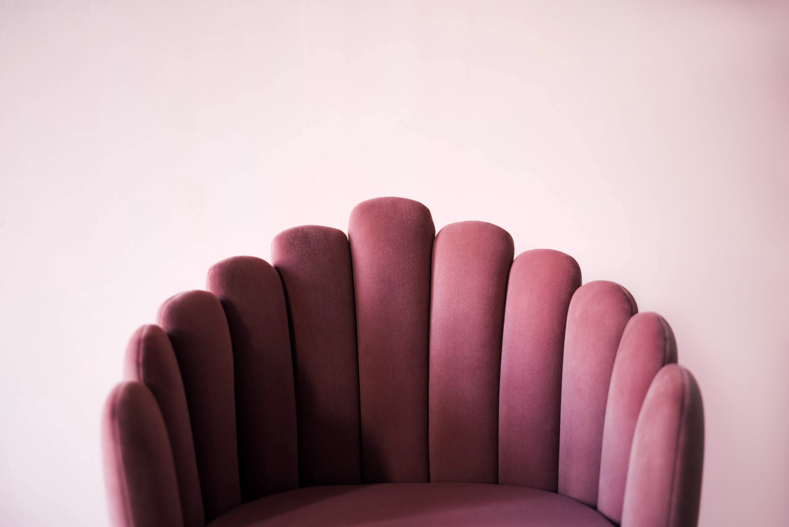 Pink textured velor armchair on a pink background. Pink armchair. Pink and white background. Design.