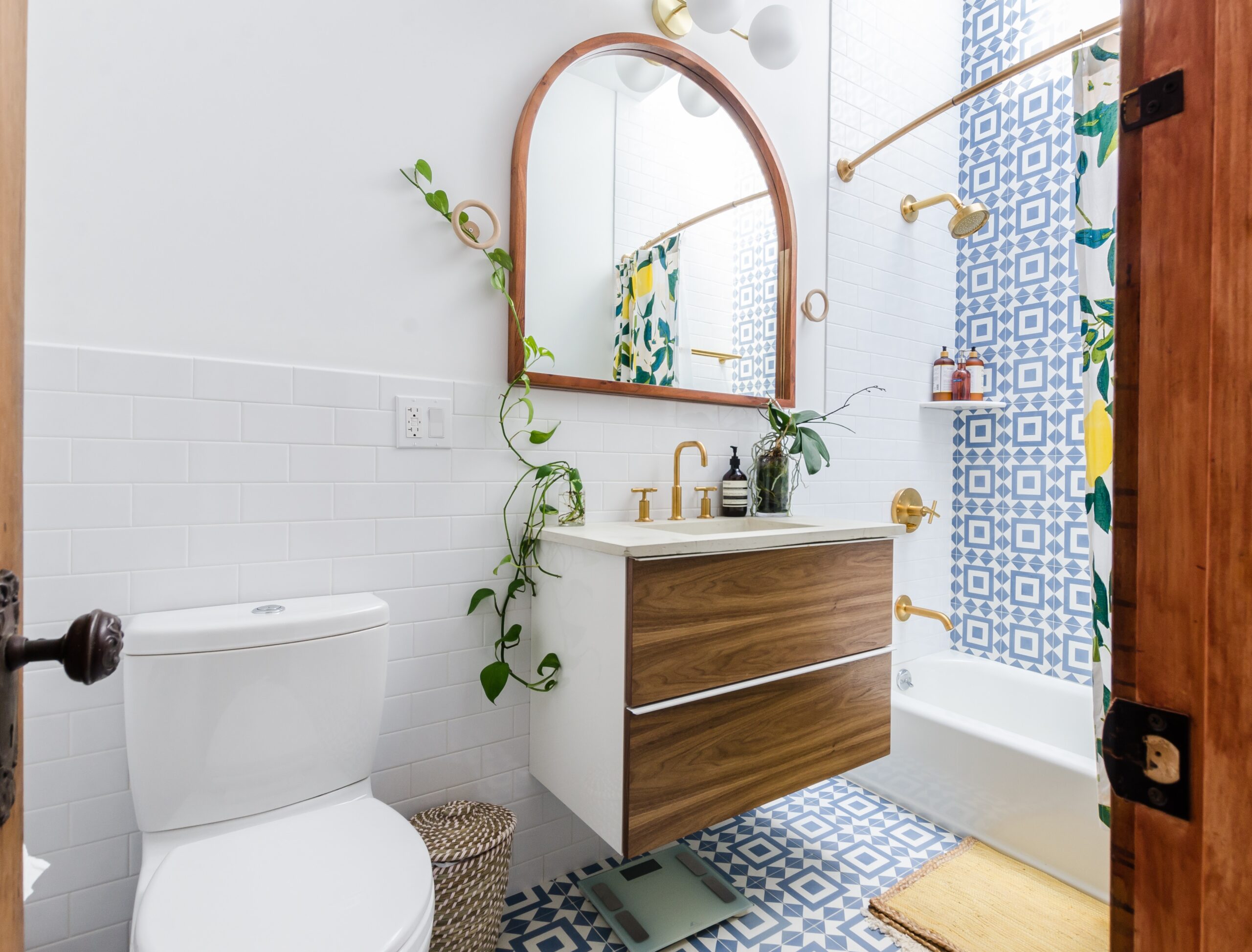 Create an accent wall using tile for a boho bathroom. Pictured: A bathroom with an accent tile wall and decor.