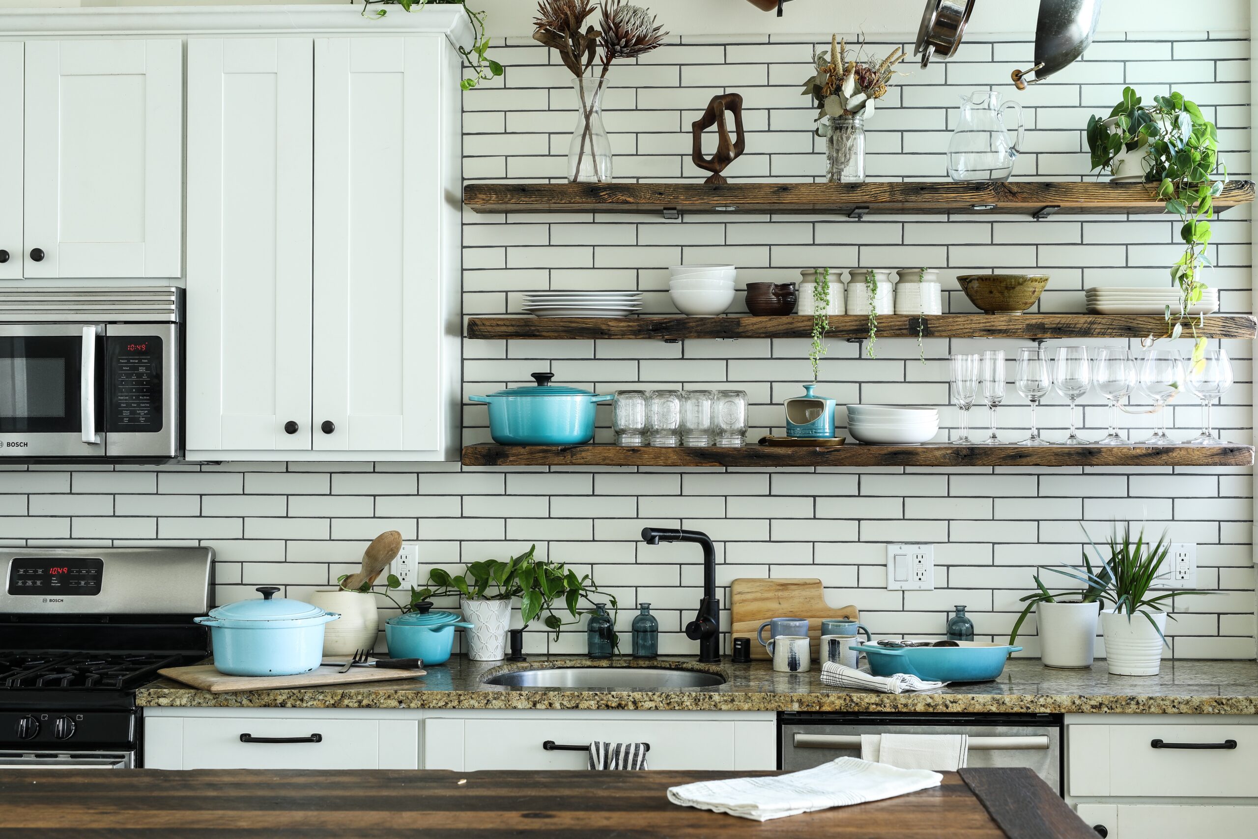 Choose the right color combinations for your kitchen grout and tile. Pictured: A kitchen backsplash with decorations.