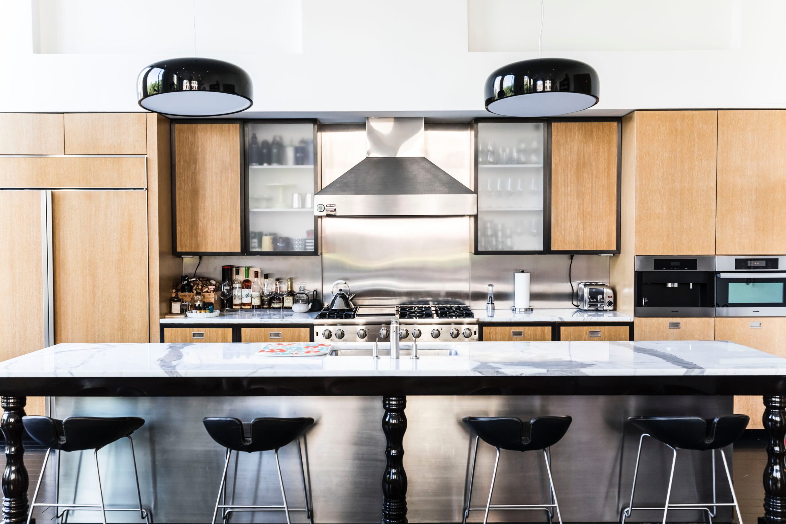 Can't decide between a farmhouse or a modern vibe? Why not try both. A black and wood kitchen countertop pairing works perfect for those wanting two different kitchen aesthetics. Pictured: Black countertops with wood cabinets.