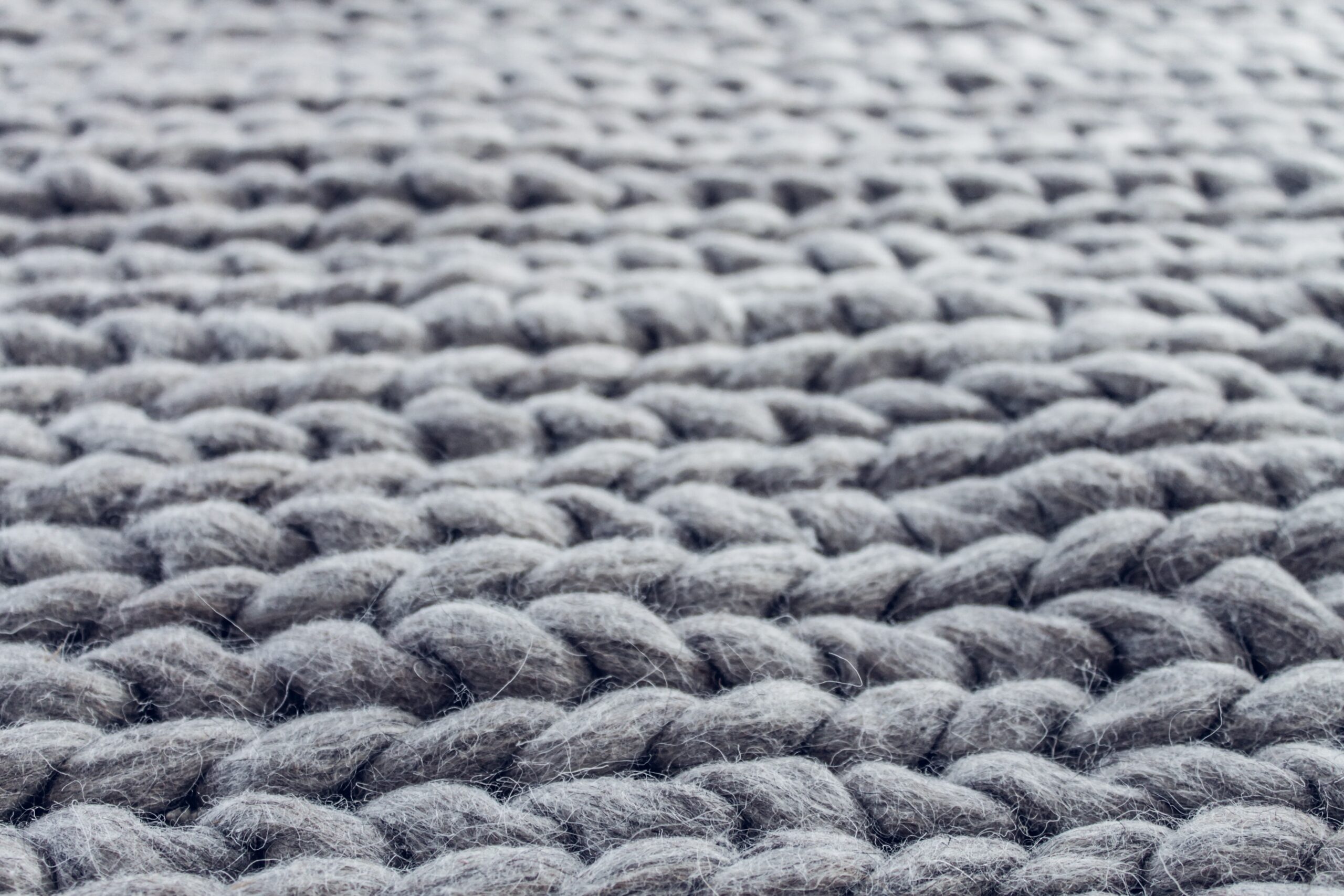 Use strips, curtain rods, or clips to hang up a rug. Pictured: A Soft Gray Rug.