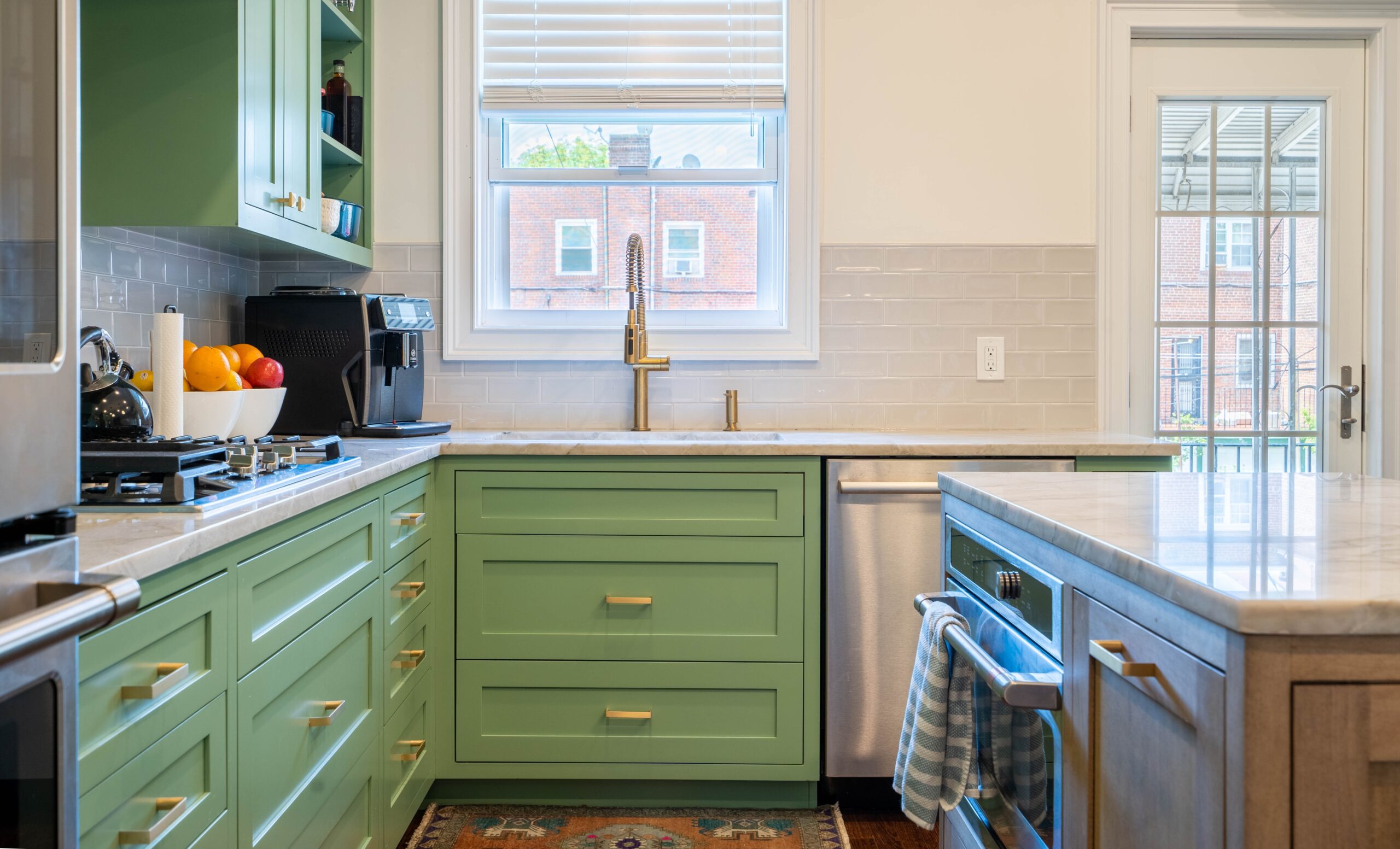 We'll see bold color choices like green as a kitchen trend in 2024. Pictured: A kitchen with green cabinetry.