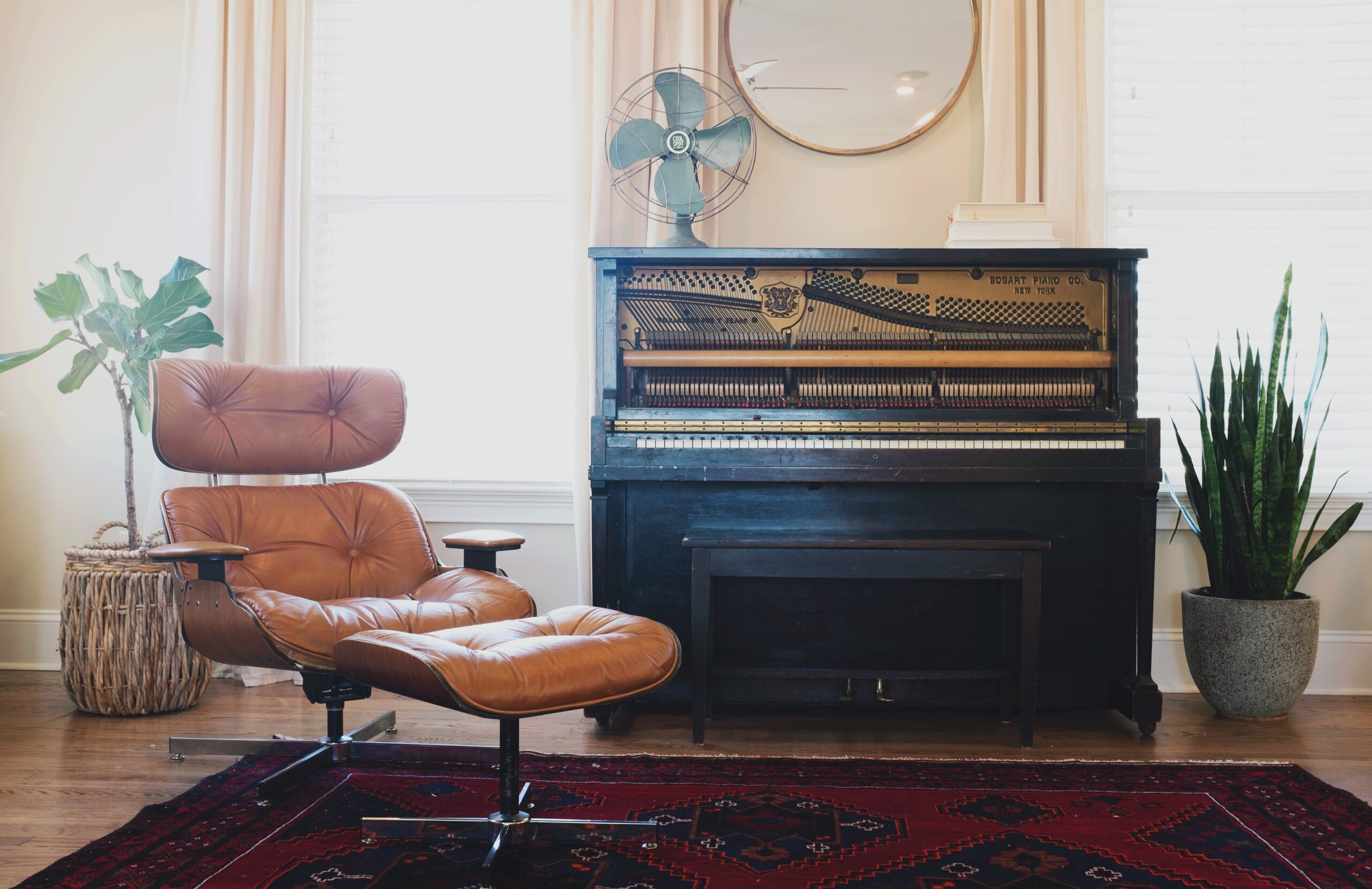 Add vintage pieces to your home for the perfect boho aesthetic. Pictured: A home with a chair, a vintage rug and a piano.