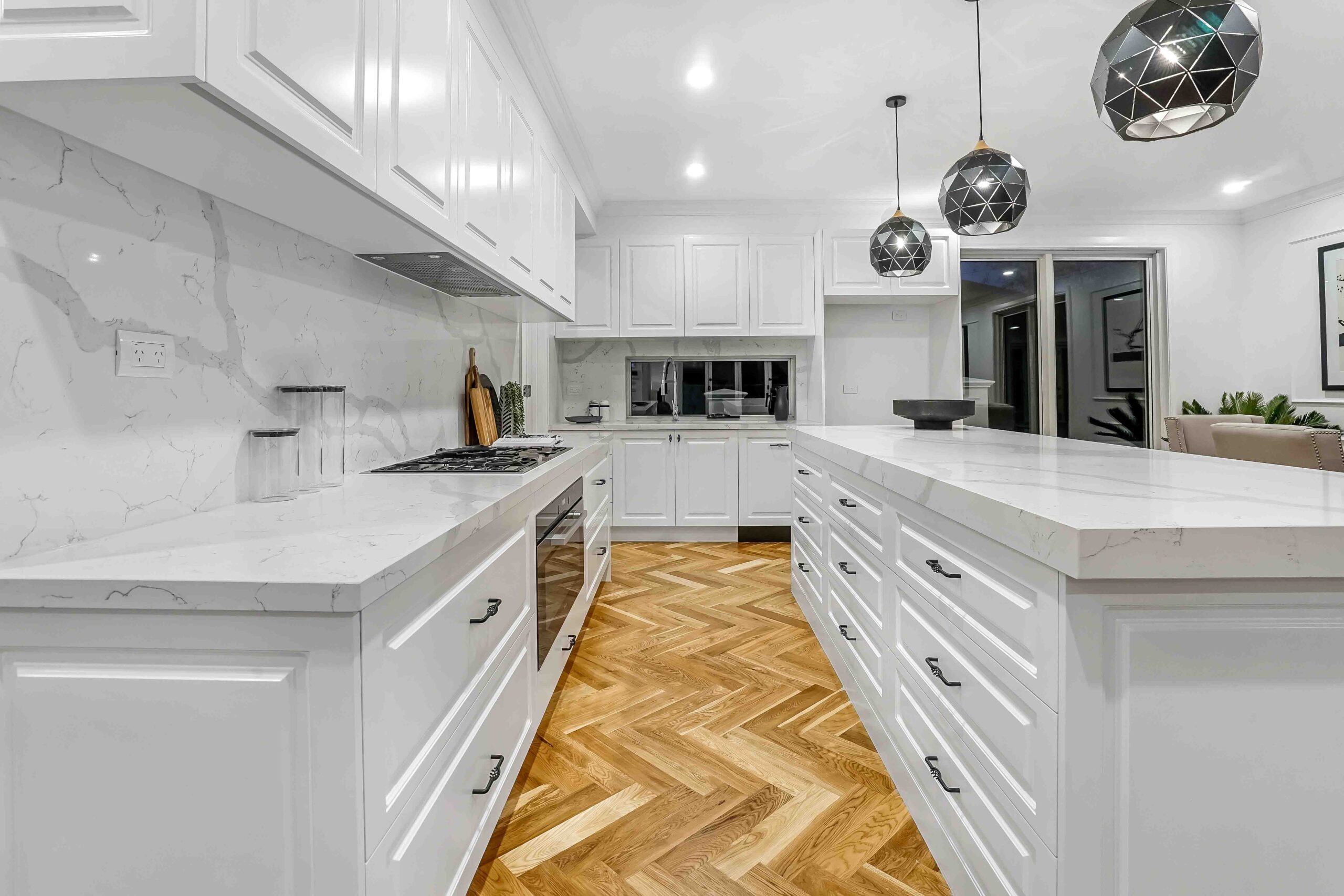 Experiment with pattern play and different types of flooring with this kitchen floor idea. Pictured: A patterned hardwood floor in a kitchen.