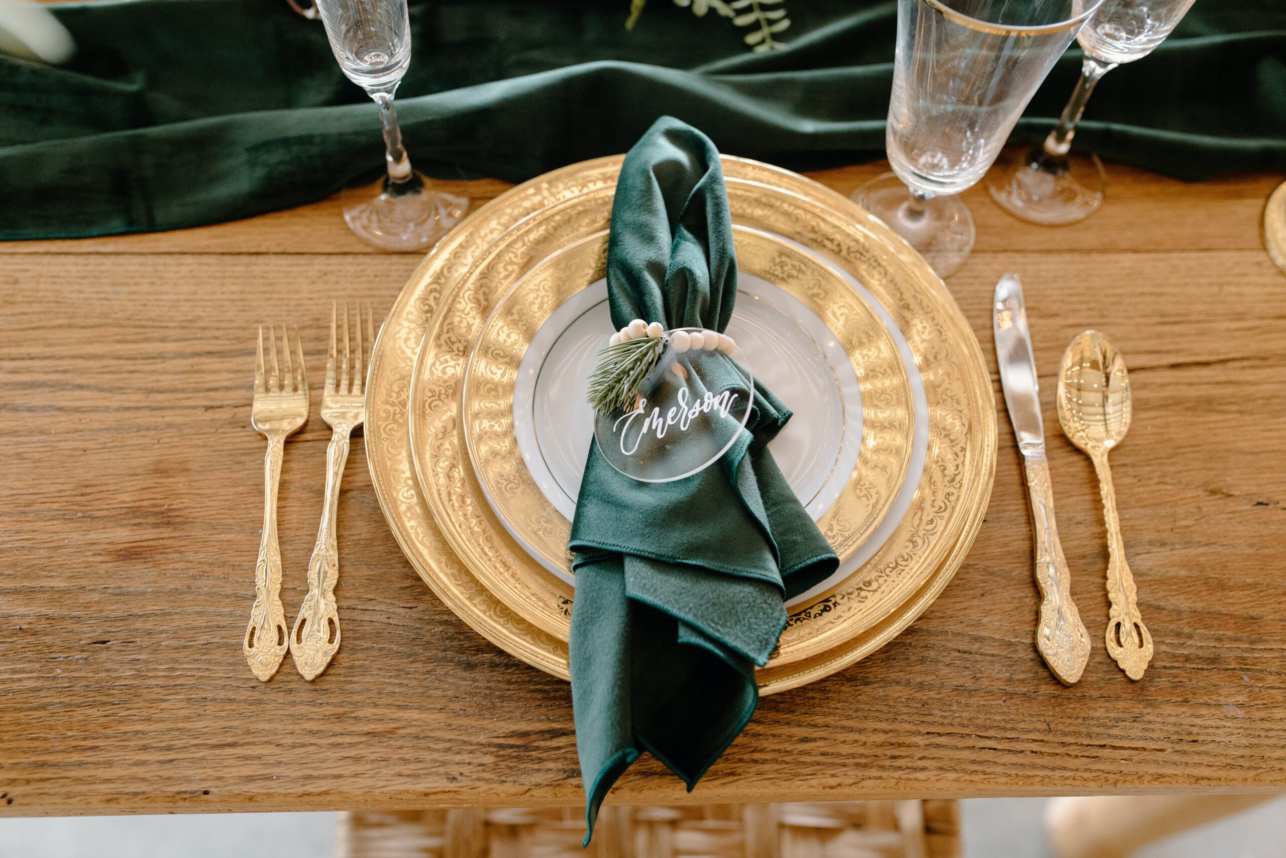 Personalize each seat or leave a gift for each of your guests on your tablescape. Pictured: A tablescape personalized with glass ornaments. 
