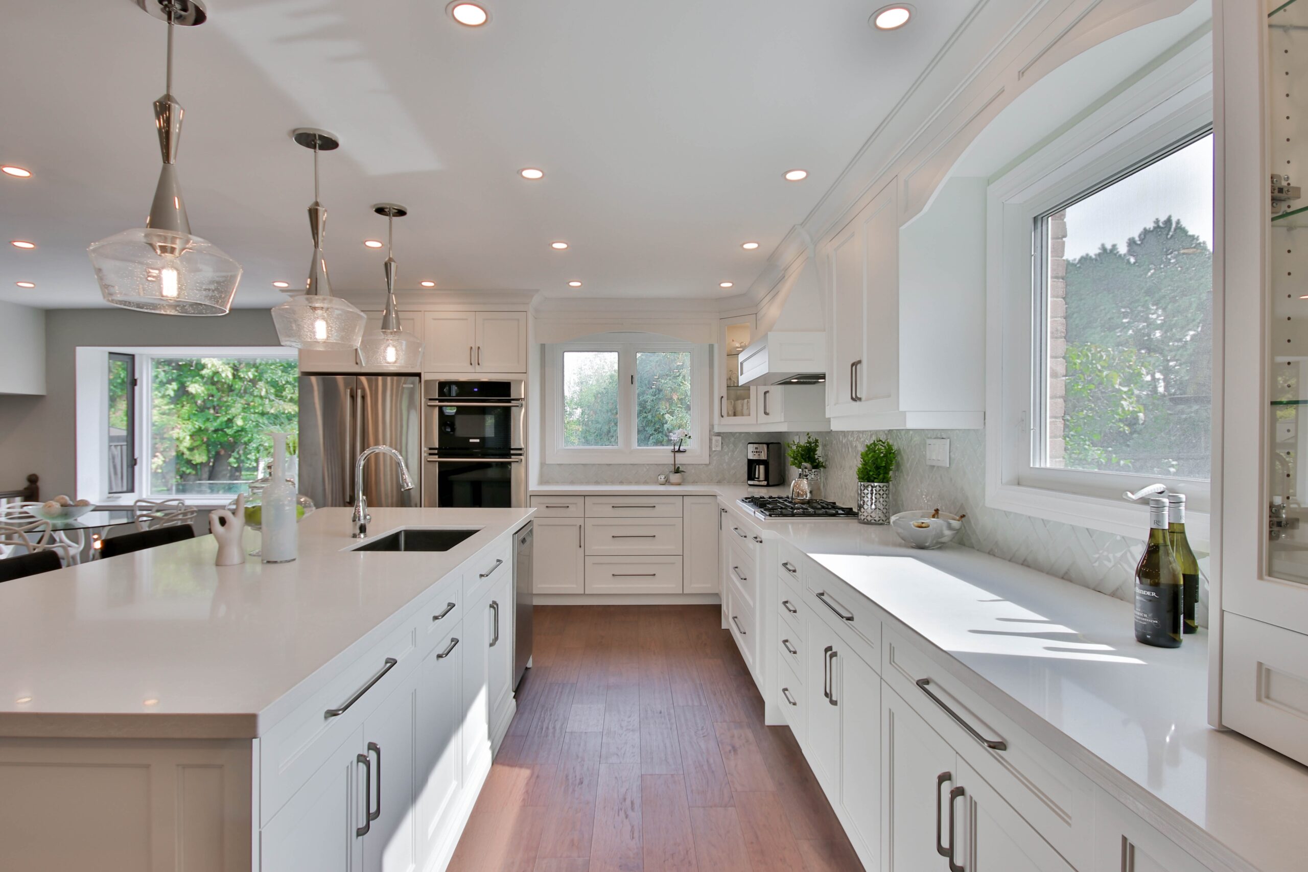 Keep things sweet and simple with this kitchen floor idea. Hardwood is easy to clean and keeps things simple when decorating. Pictured: A kitchen with hardwood flooring and white cabinetry. 