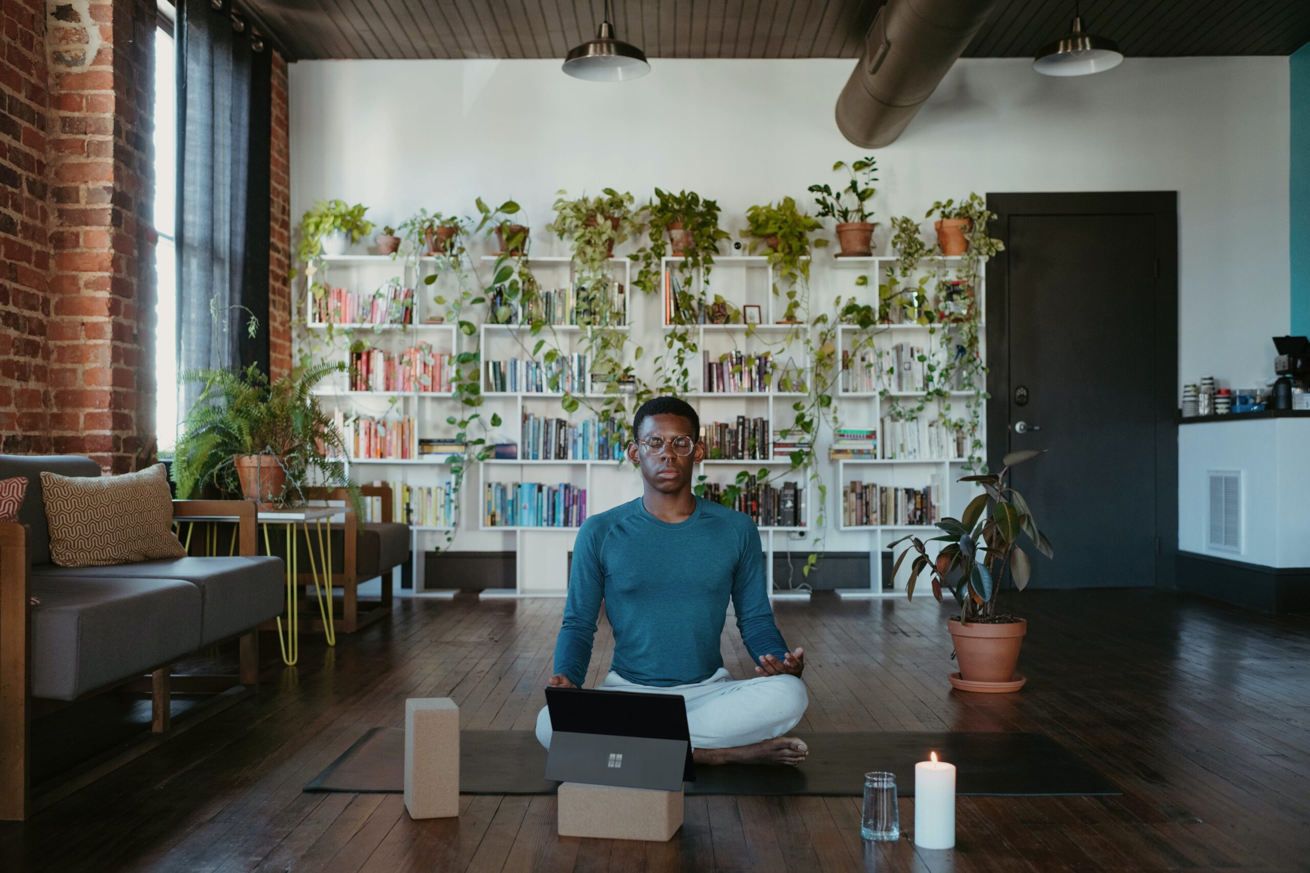 Plants are said to promote relaxation and reduce stress. Incorporate these into your zen meditation room for peaceful and mindful meditation. Pictured: A man doing yoga with plants in the background.