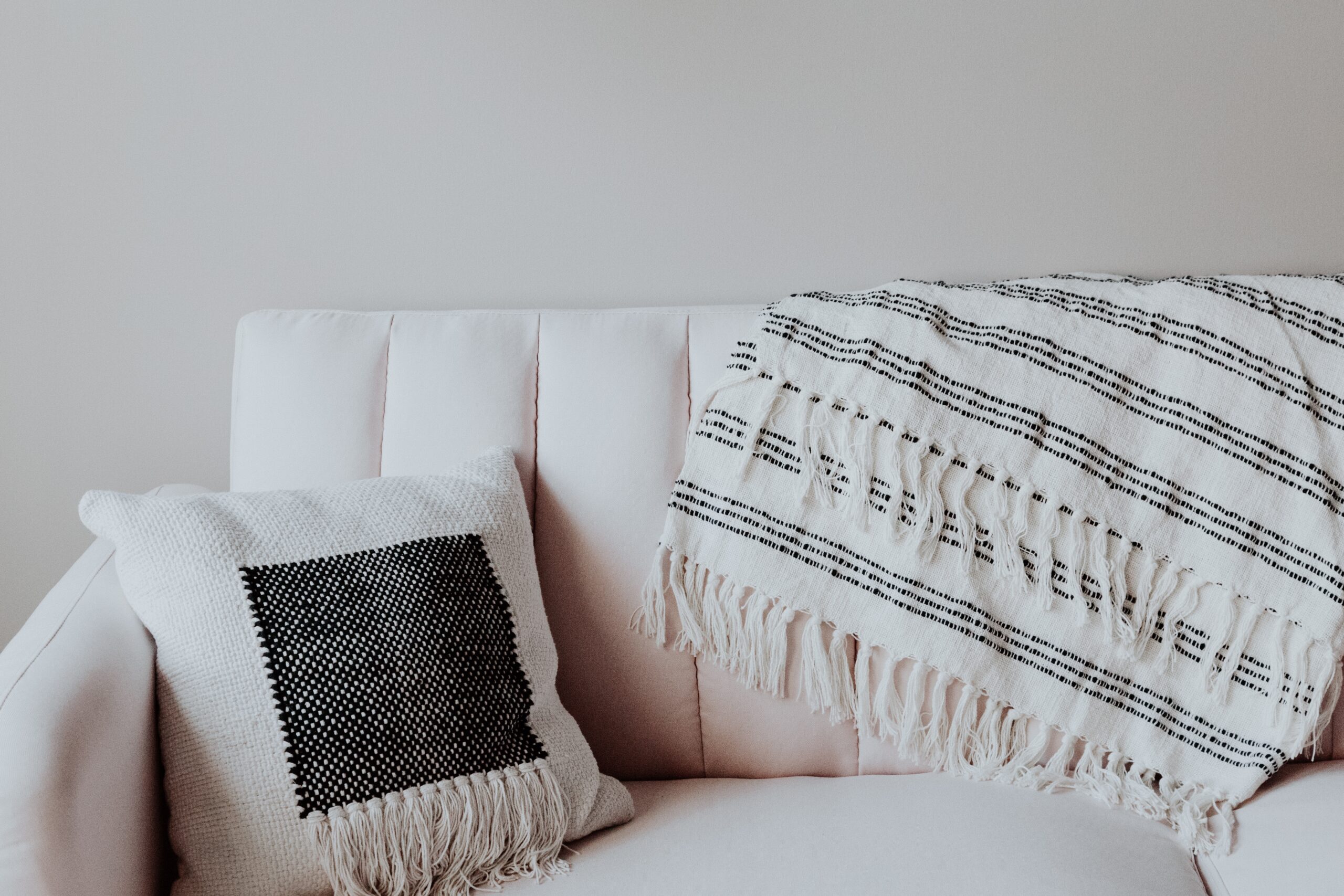 Texture and softness are both elements that should be incorporated into your zen room for mindful meditation practice. Pictured: A couch with a throw blanket and pillow.
