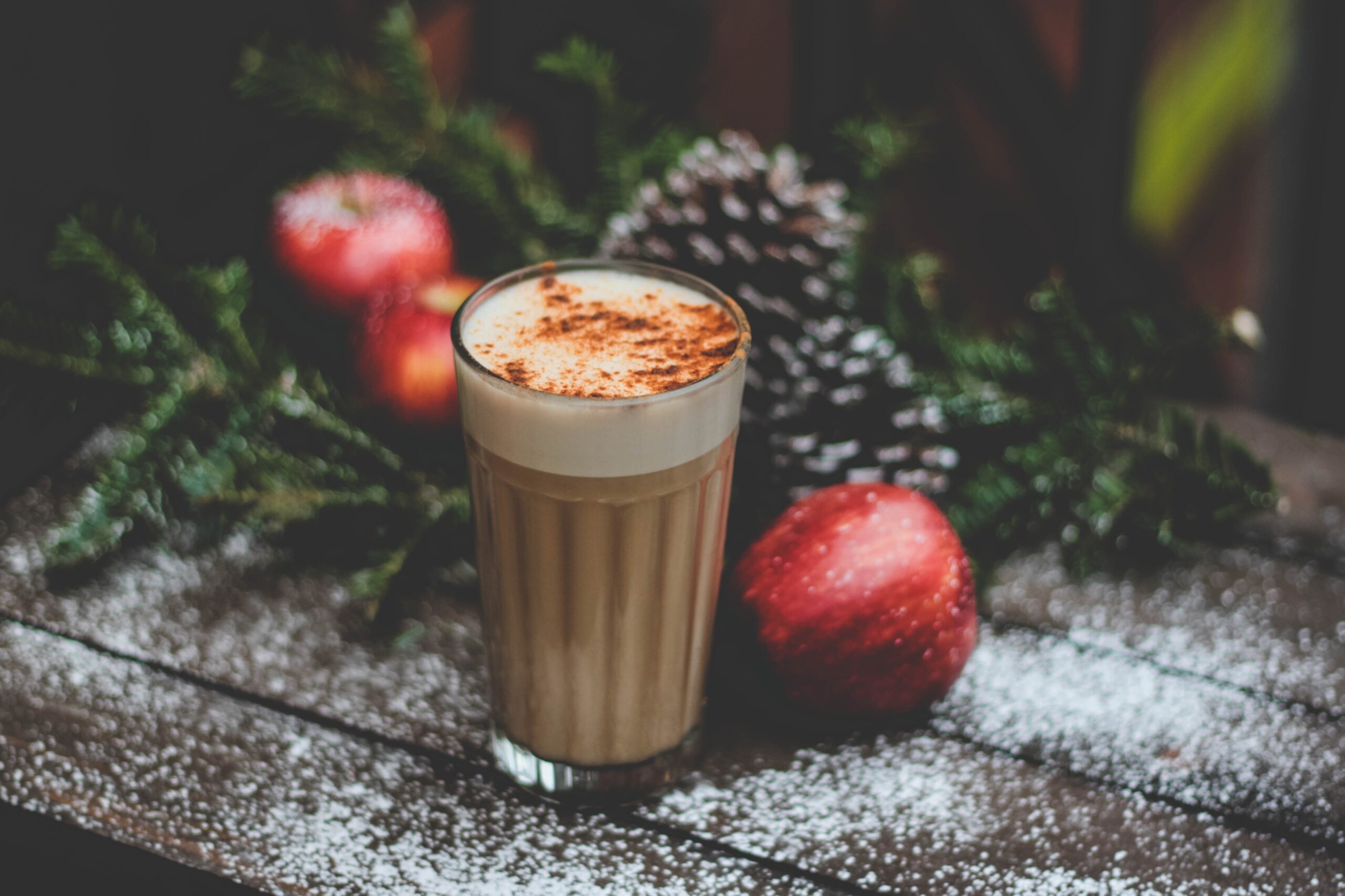 A combination of two fall flavors, apple and chai, this Thanksgiving cocktail is perfect for your gathering. Pictured: A chai tea latte with apples beside it.