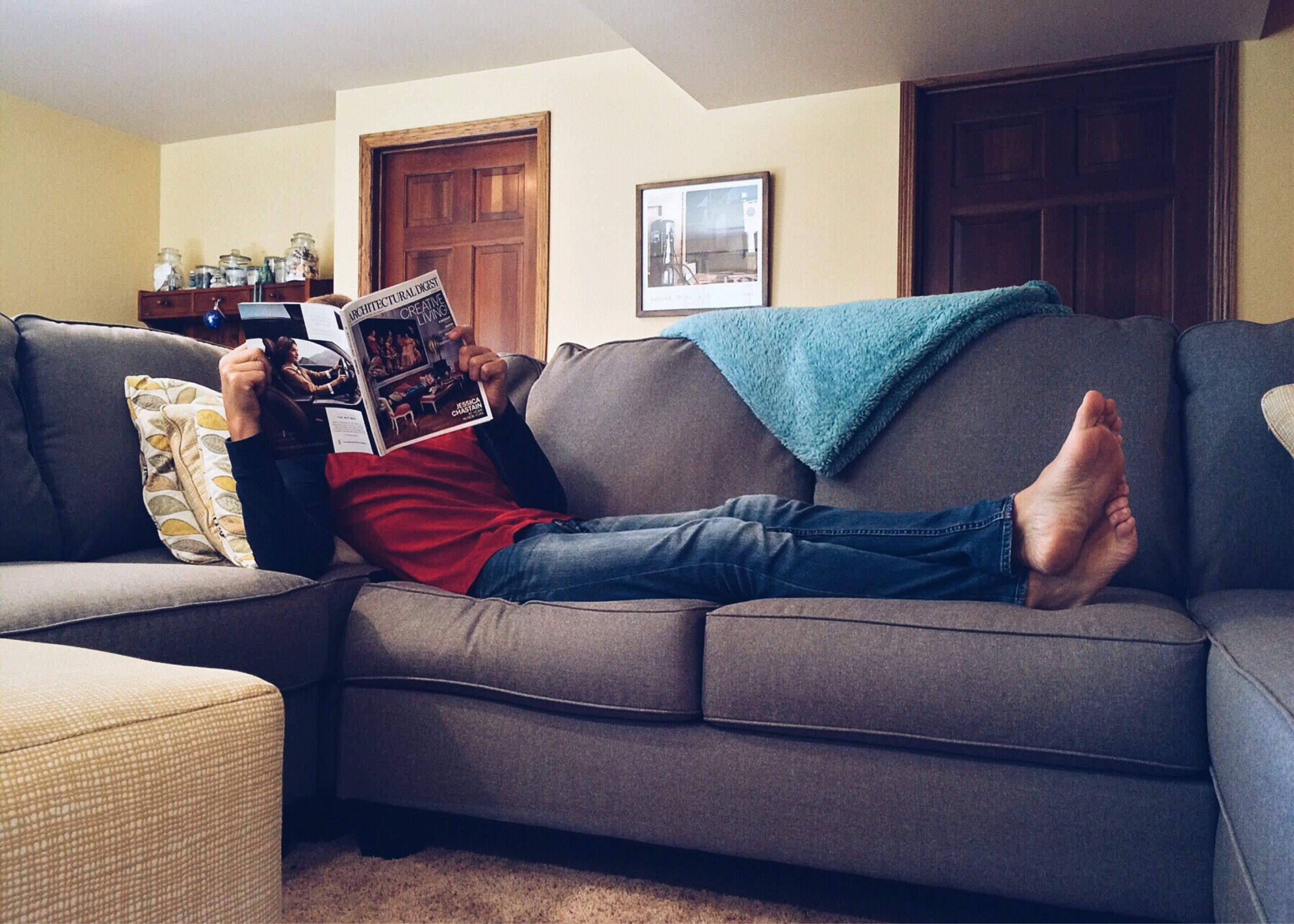 A man reading a magazine on the couch