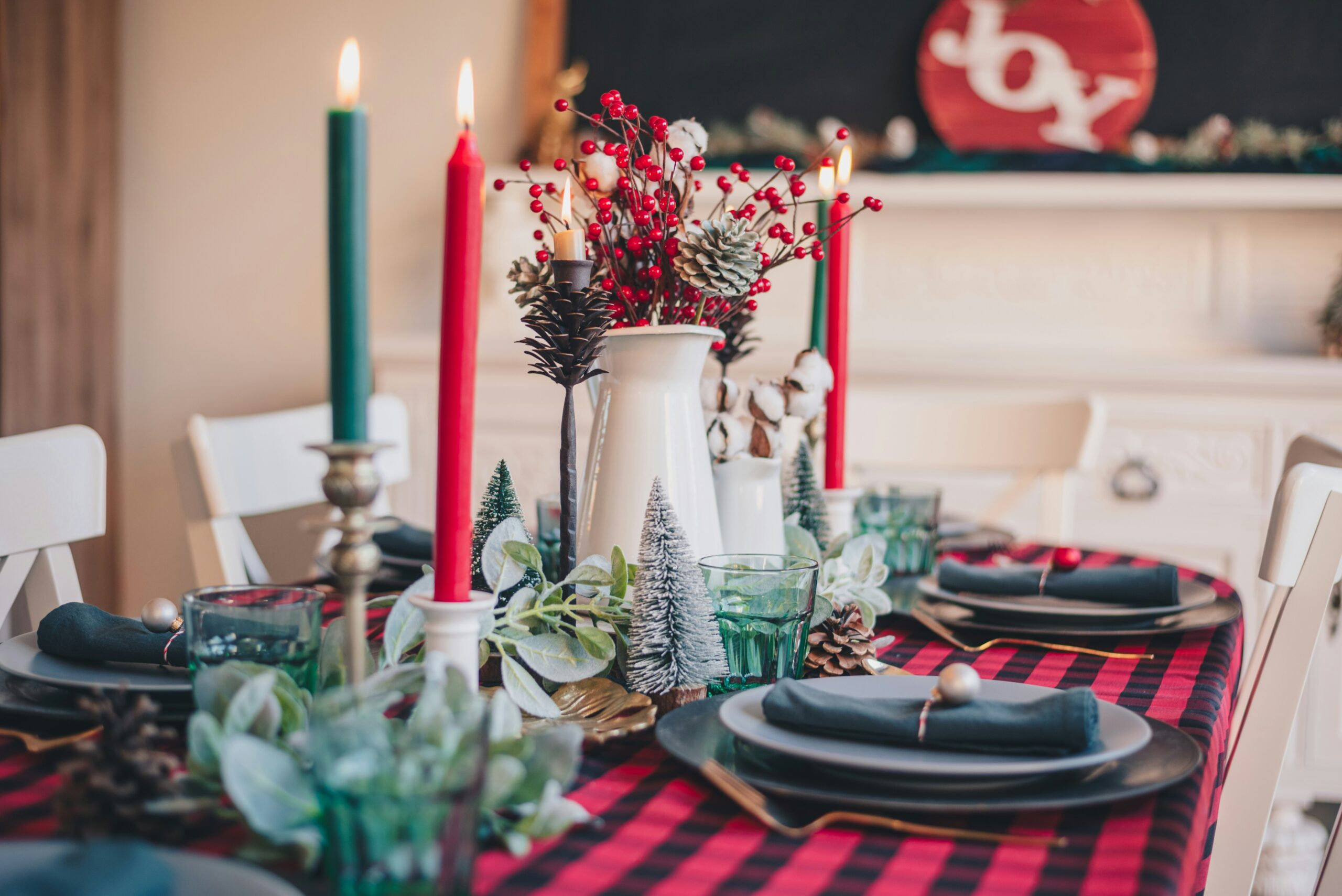 Utilize Kwanzaa colors in your dining room with tablecloth, a table runner, plates, candles, napkins and silverware. Pictured: A dining room table with black, red and green Holiday decor.