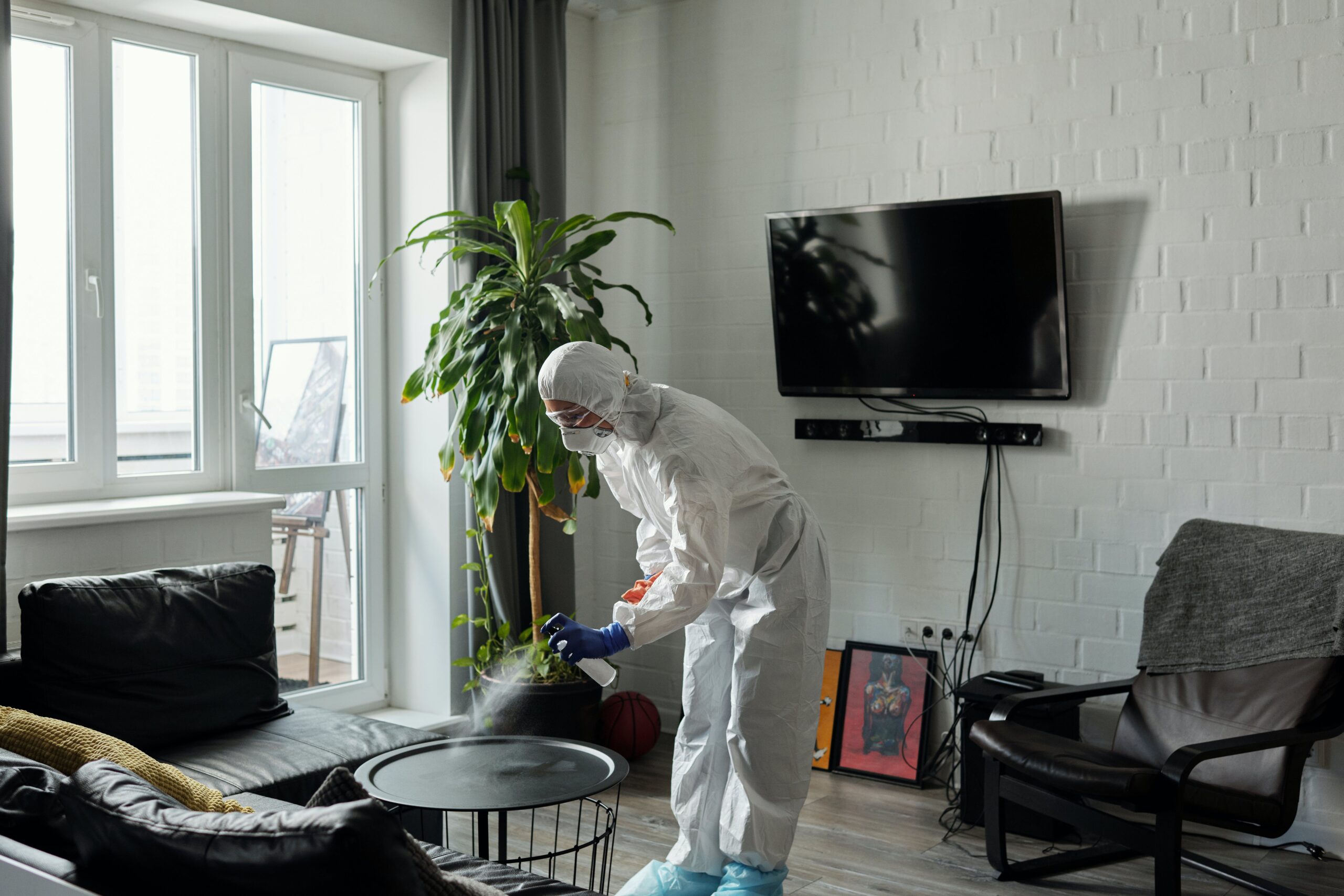 Person cleaning in hazmat suit