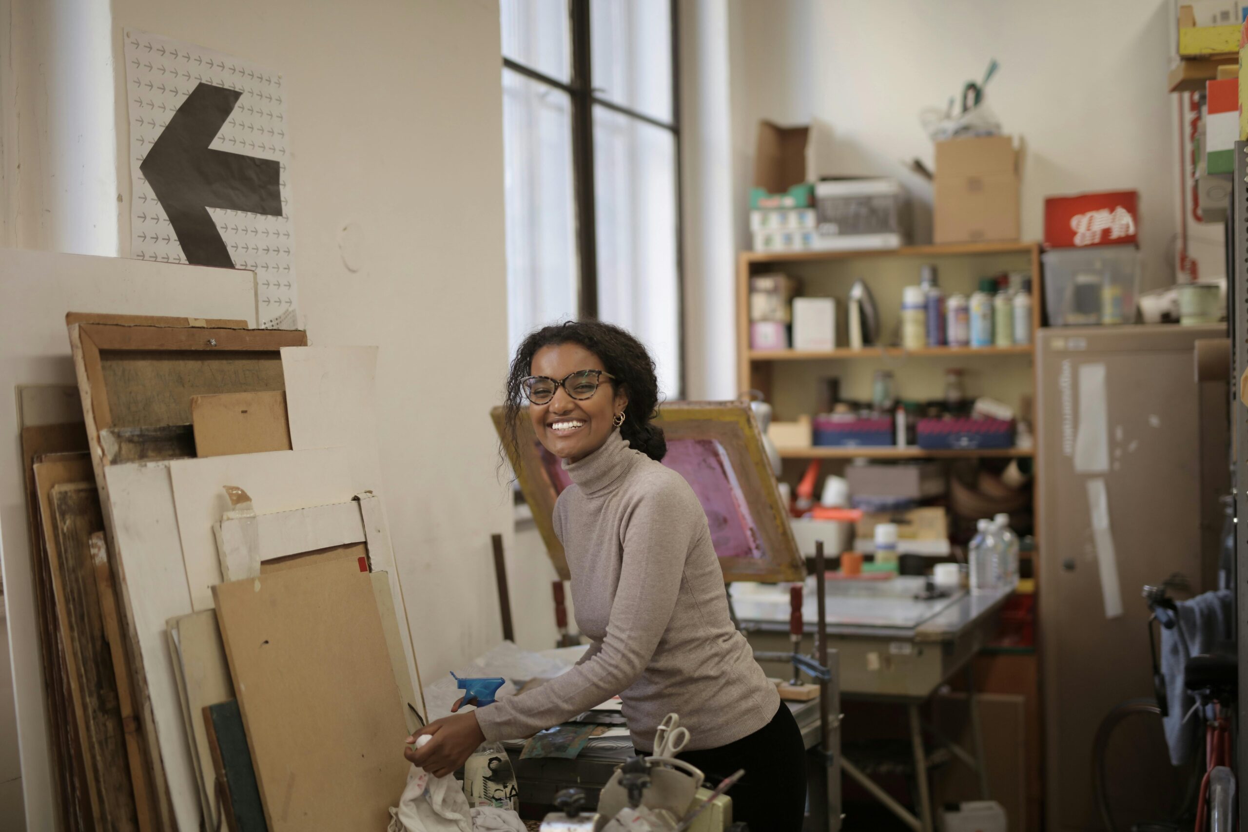 A smiling woman in a paint studio