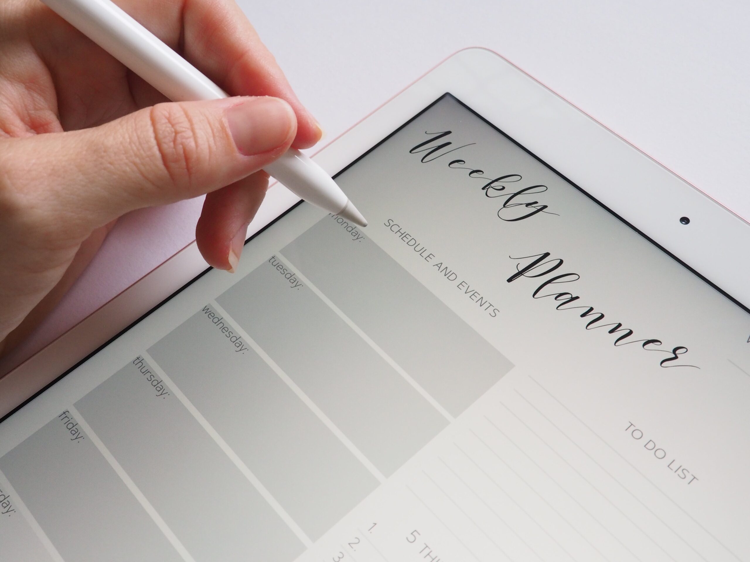A hand writing on a digital planner
