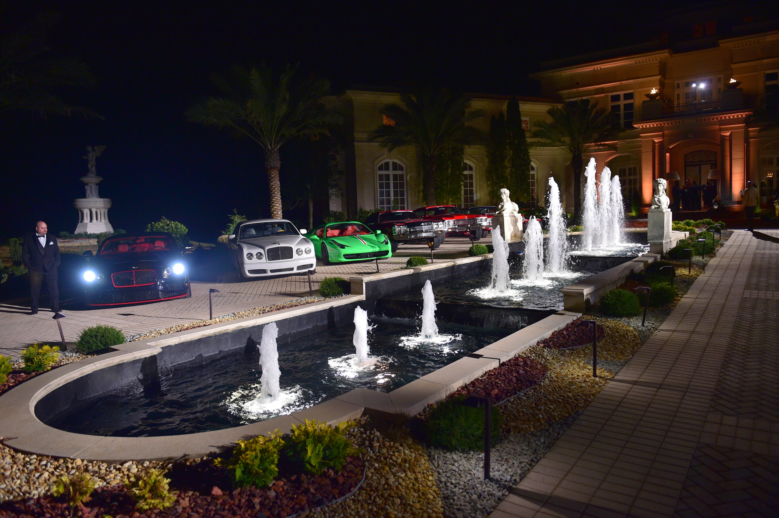 Take a look inside Rick Ross' massive Georgia house. Pictured: An outside view of his mansion and car collection.