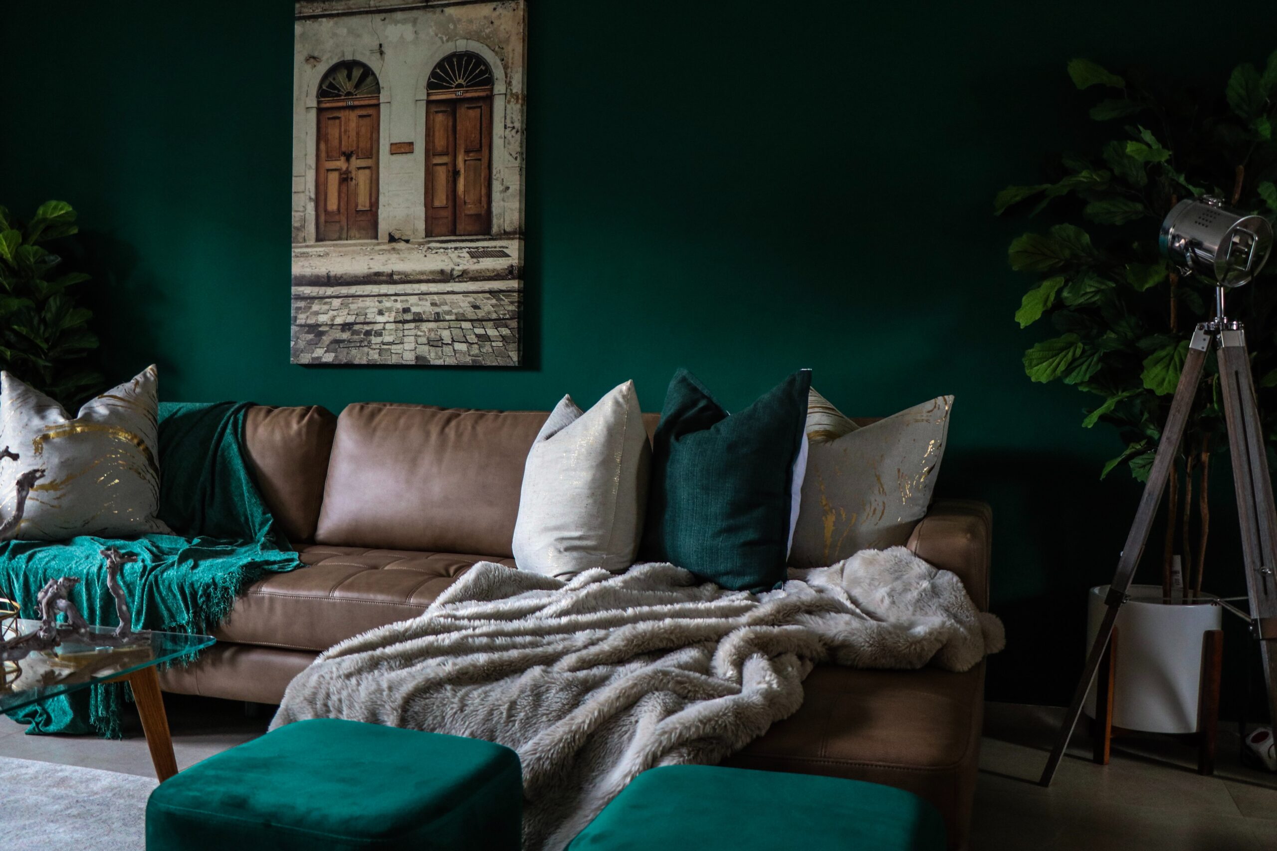Learn how to clean a leather couch with these products which can remove stains and keep it looking polished. Pictured: A leather couch in a living room with throw pillows and blankets.