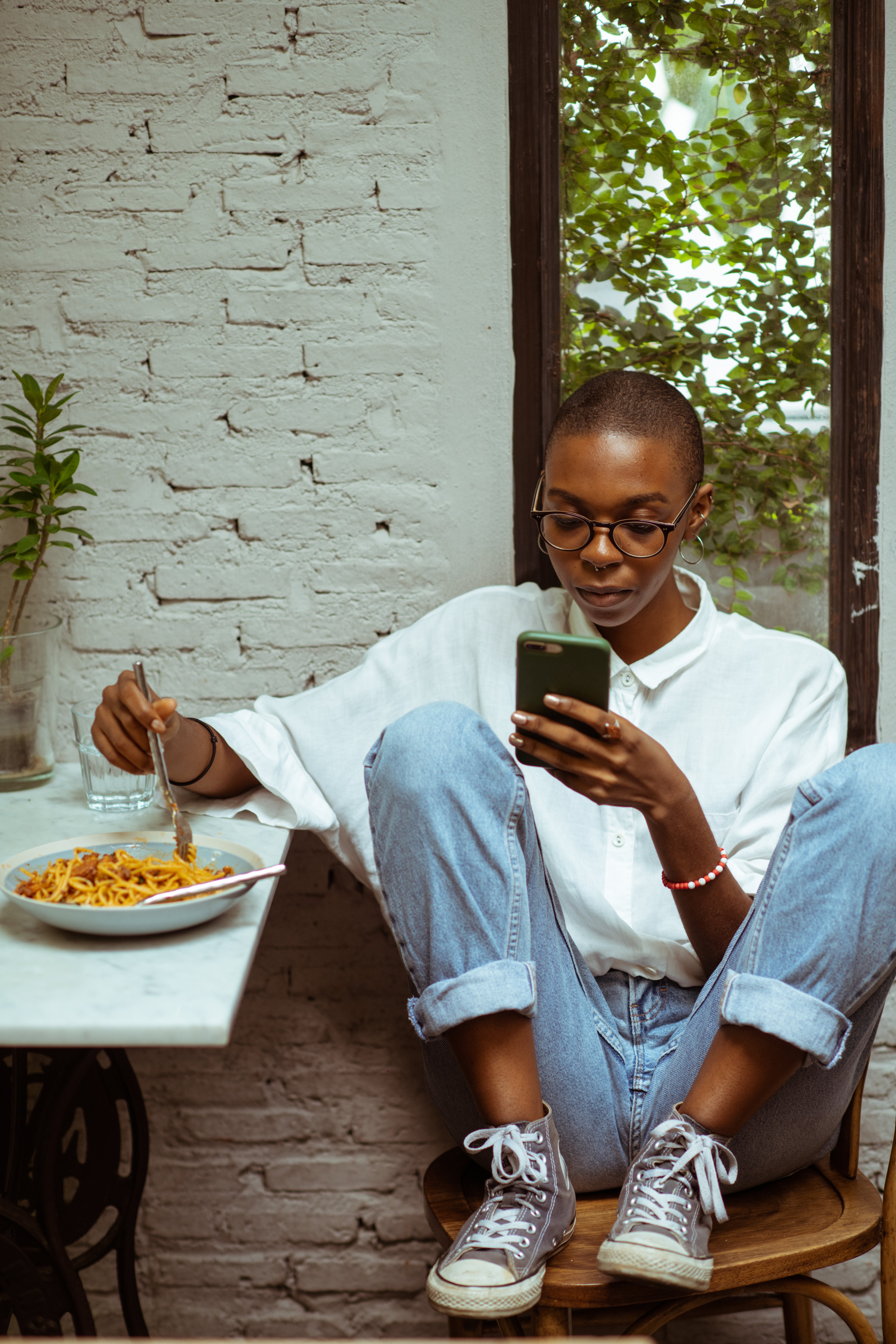 Woman eating pasta on phone