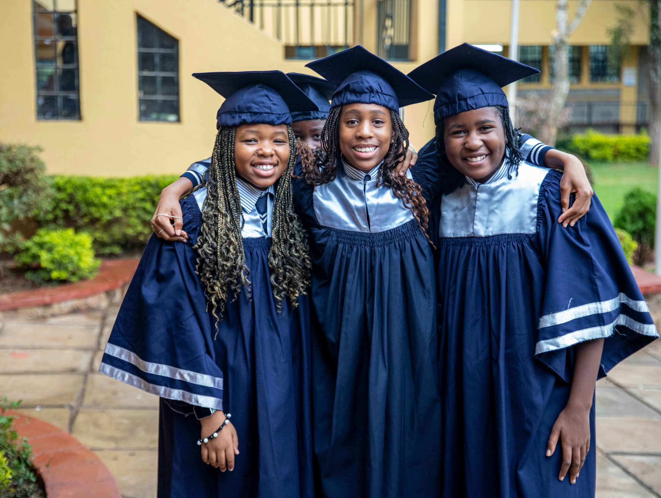 Three young graduates smiling for the camera