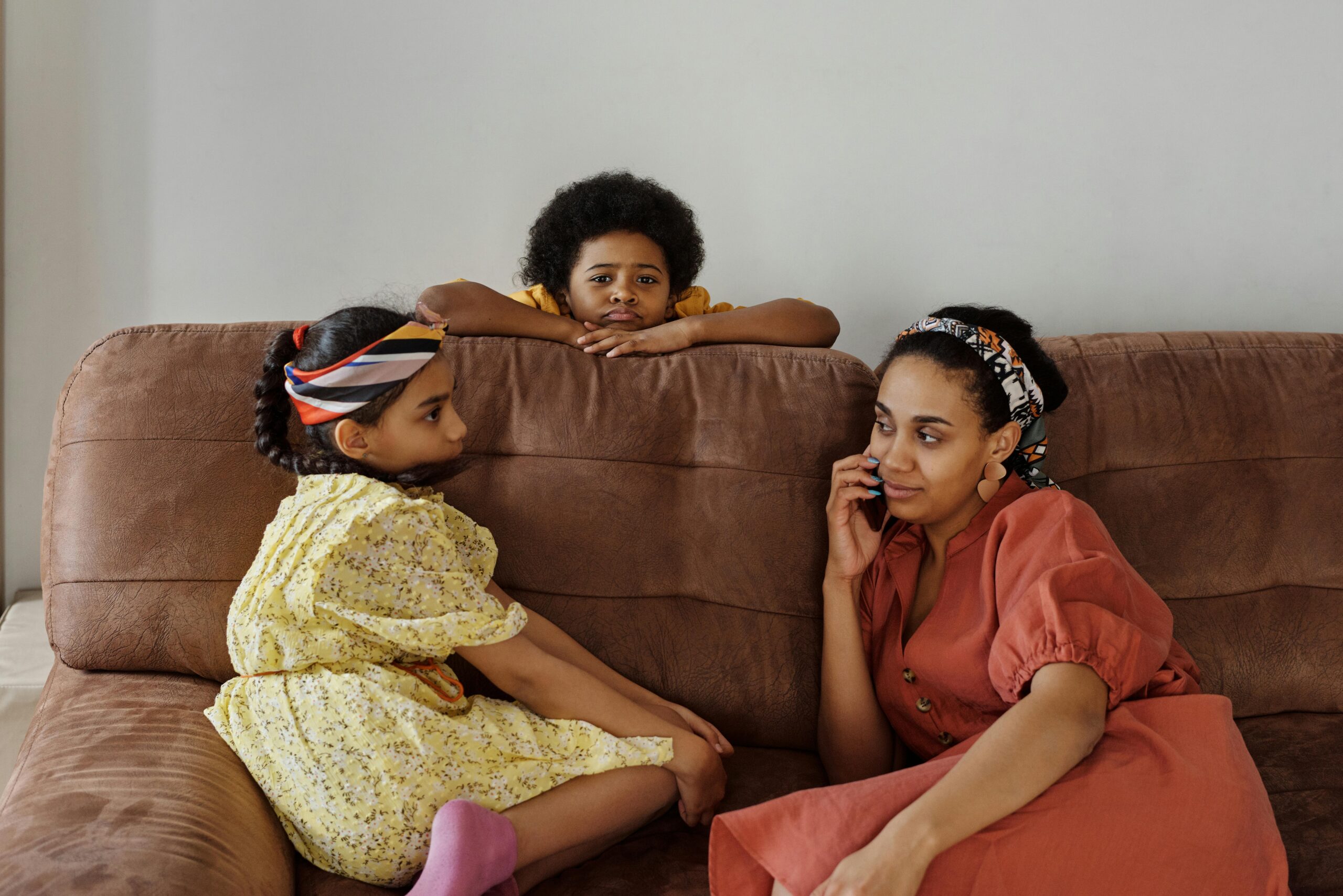A mother talking to her kids on the couch.