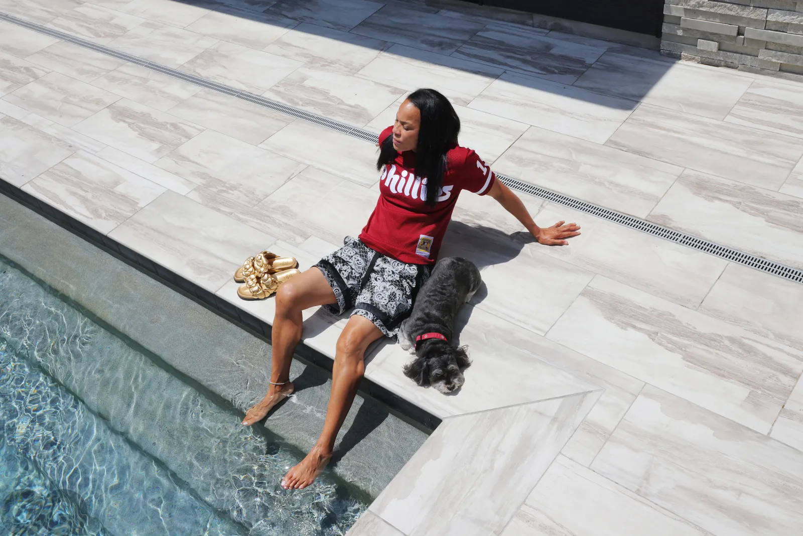 Where does Dawn Staley live? The South Carolina WBB coach has made Columbia, SC her permanent home. Pictured: Dawn Staley with her dog, Champ, sitting by the pool at her house