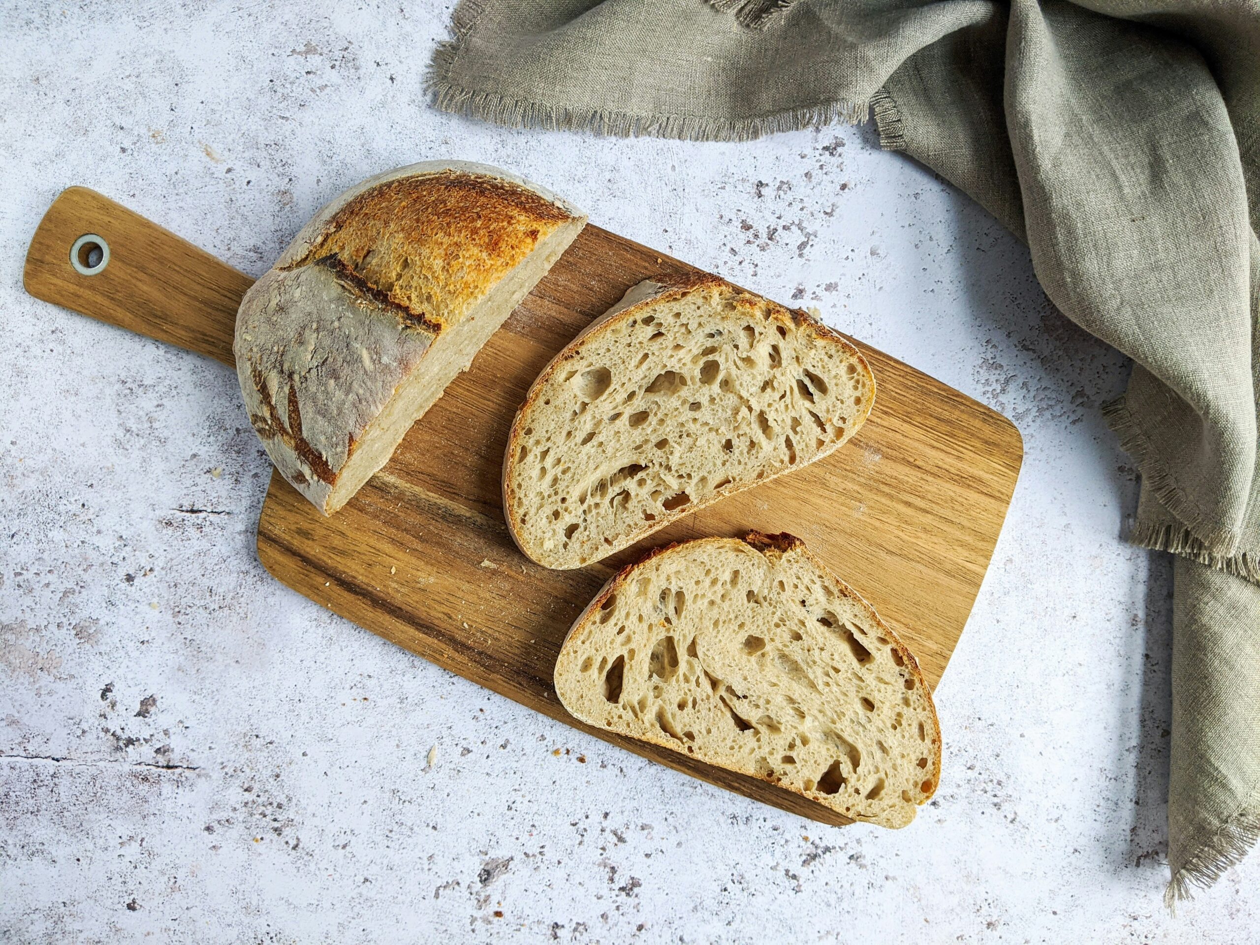 Wood is one of the best materials for a cutting board. Here are some of the best types of wood that work well in a cutting board. Pictured: A cutting board with sourdough bread