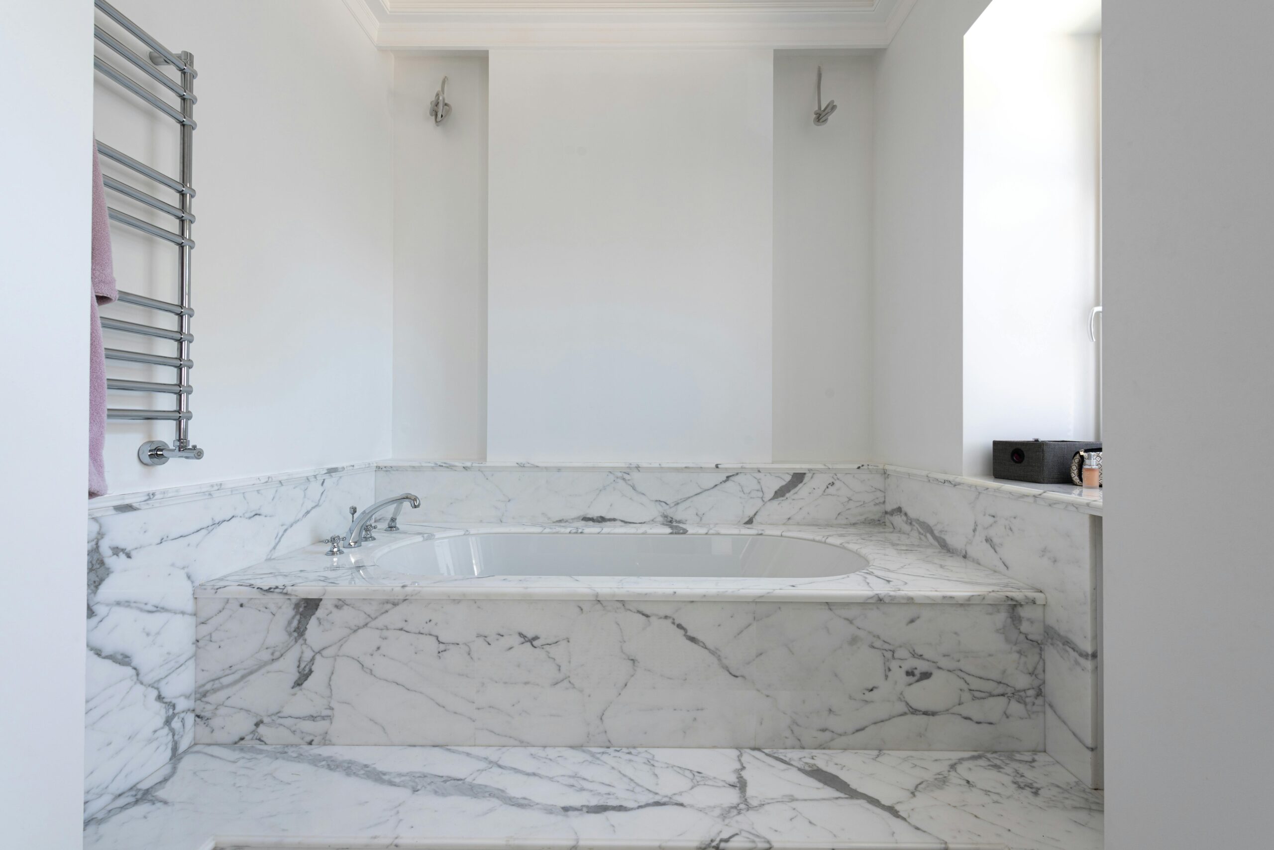 Here's how white Venetian plaster gives your home that glossy and marble luxe look. Pictured: White Venetian plaster in a bathroom