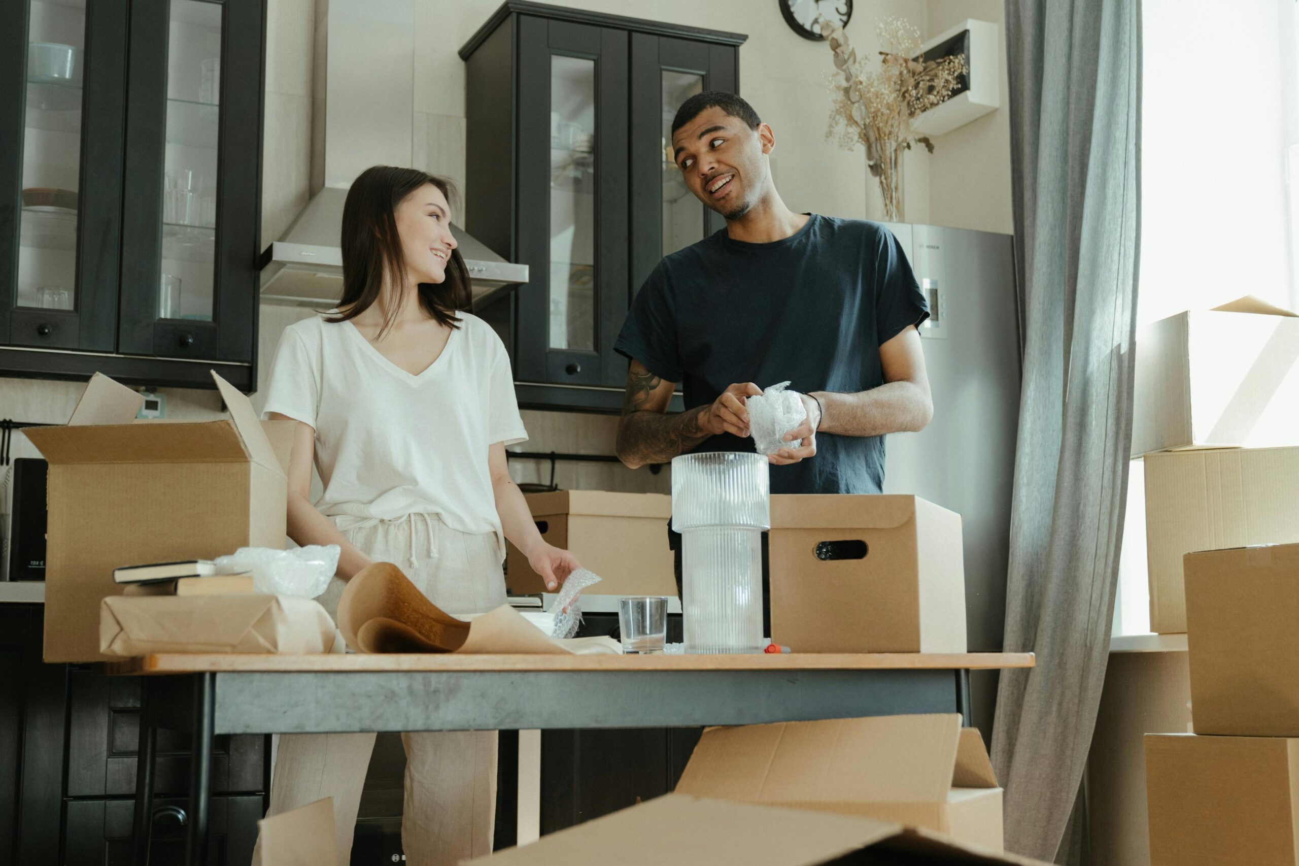 A smiling couple unpacking moving boxes