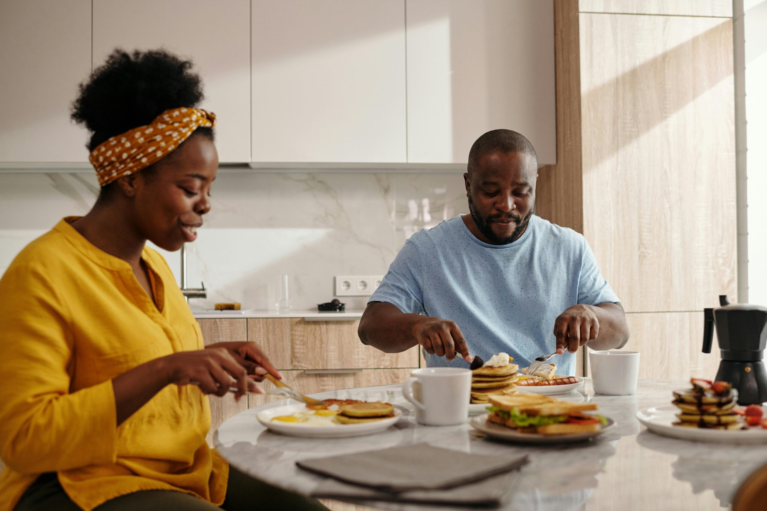 A couple eating at a kitchen table.