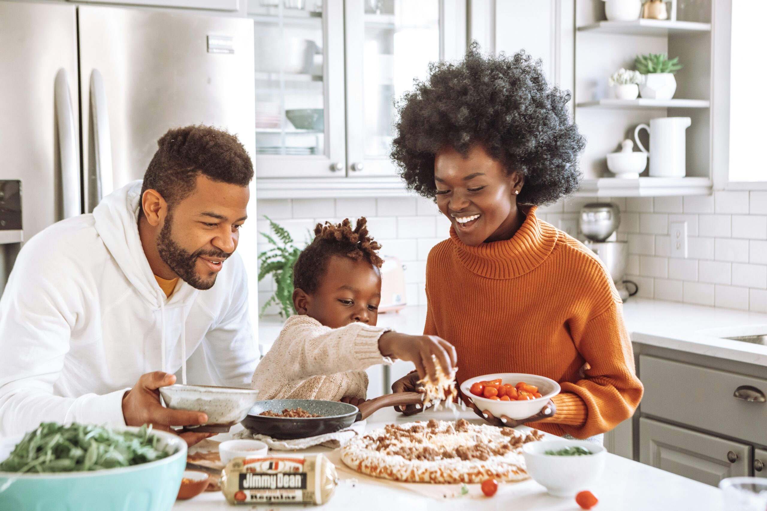 A woman, man, and child preparing a meal