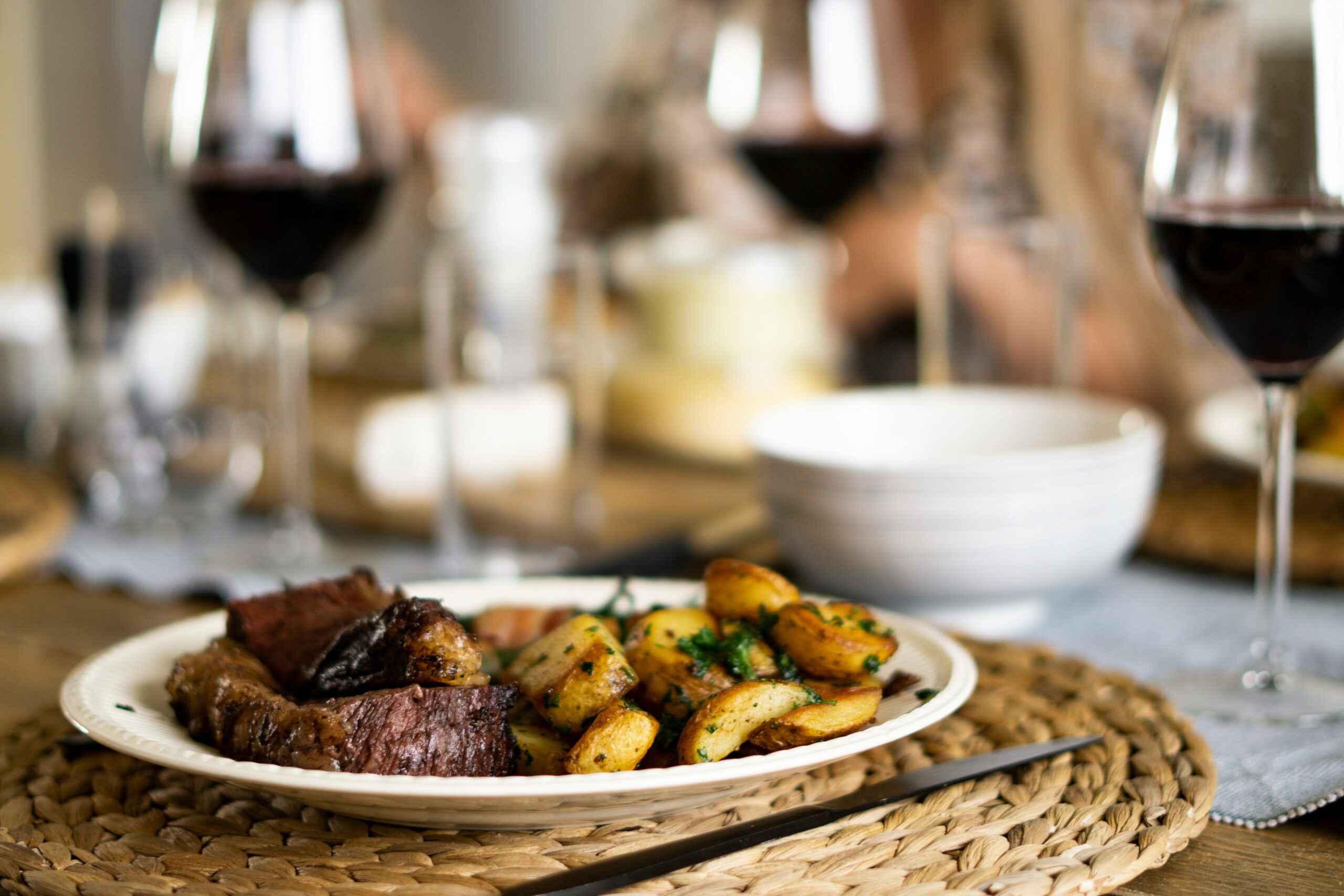 If you have a bottle of sherry wine in your pantry or fridge, use ut as a mirin substitute. Pictured: sherry wine in the background of a steak and potatoes meal