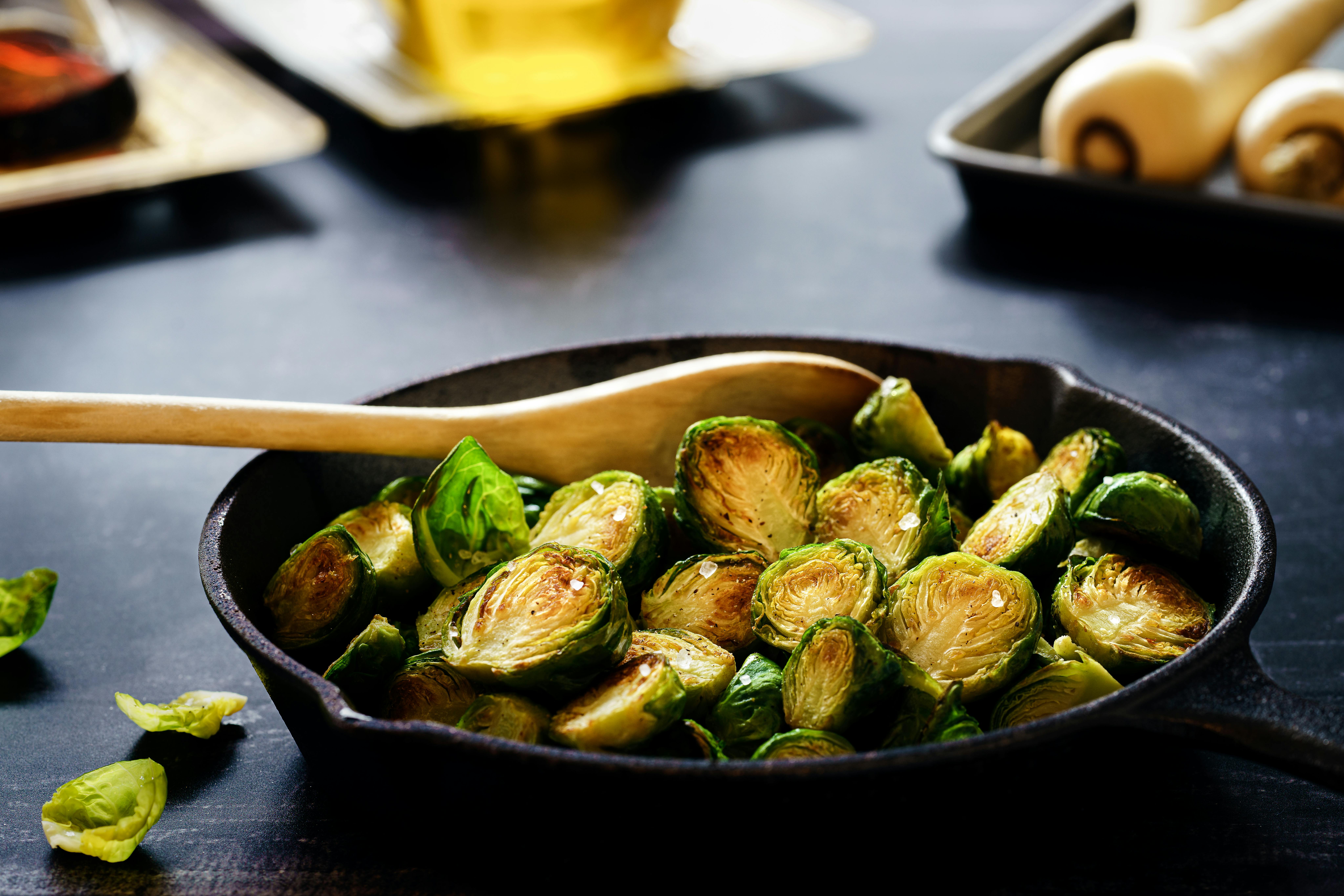 This cast iron set from Member's Mark is one of the best cookware sets for gas stove cooking. Pictured: Brussel sprouts in a cast iron pan