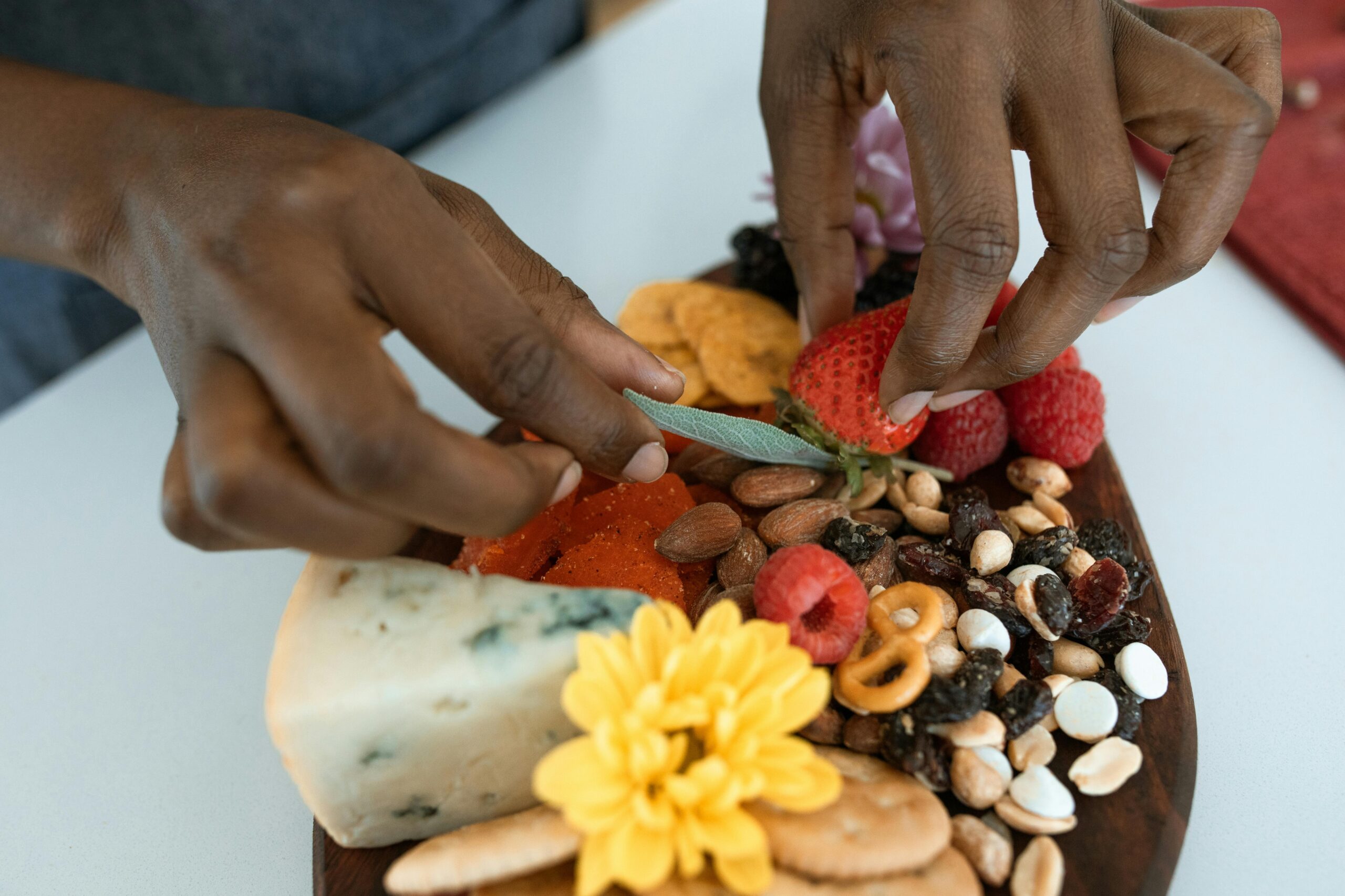 A woman arranging ingredients on an artisan charcuterie board