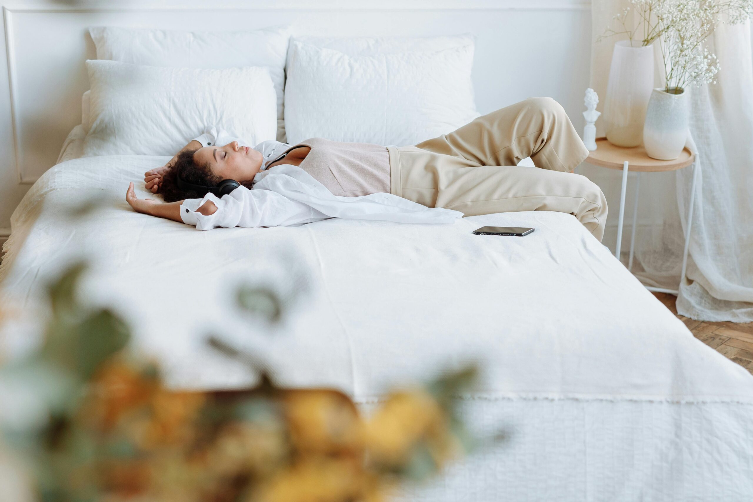 A woman laying on a white bed