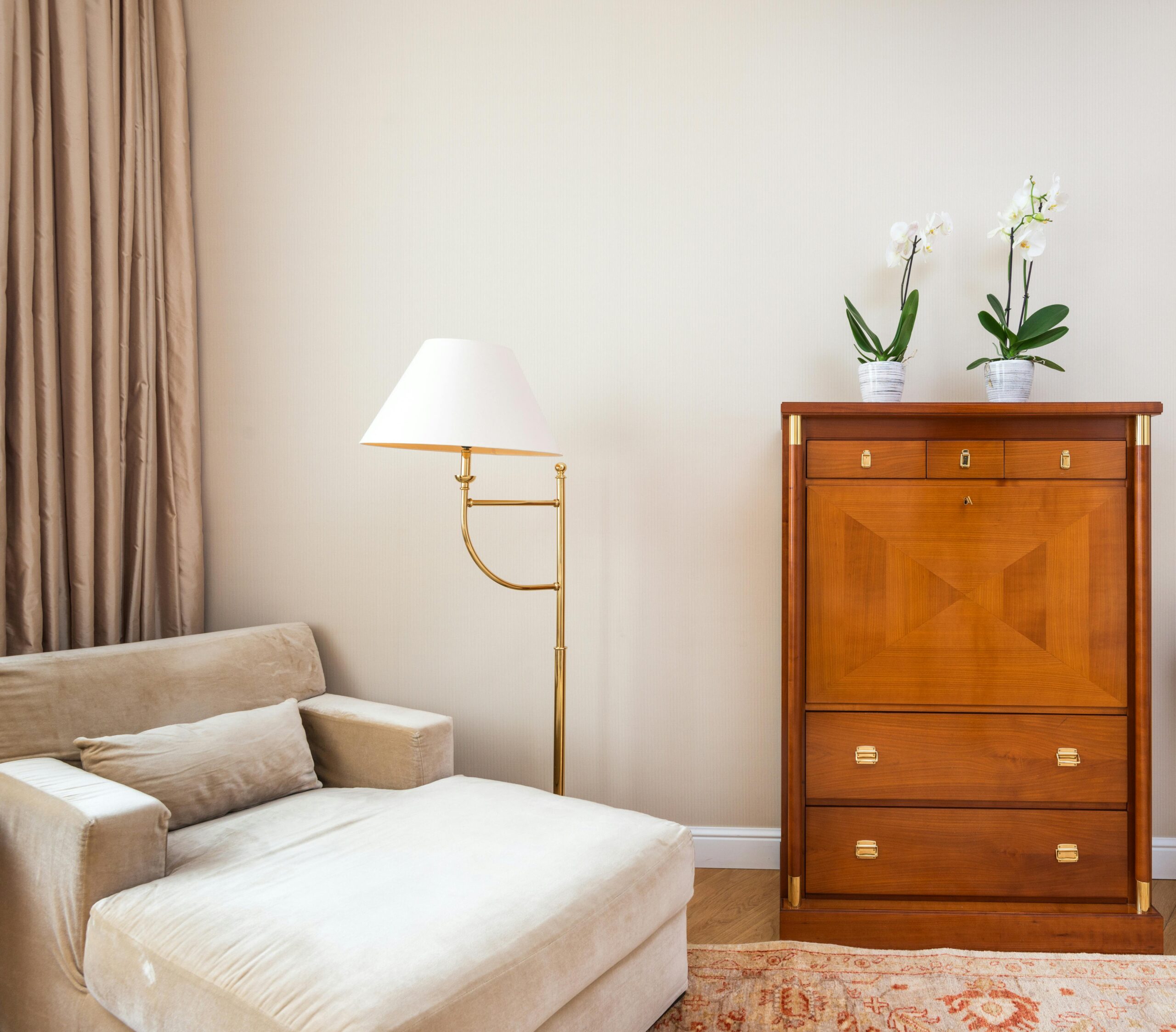 A white living space with a desk, lamp, and chair