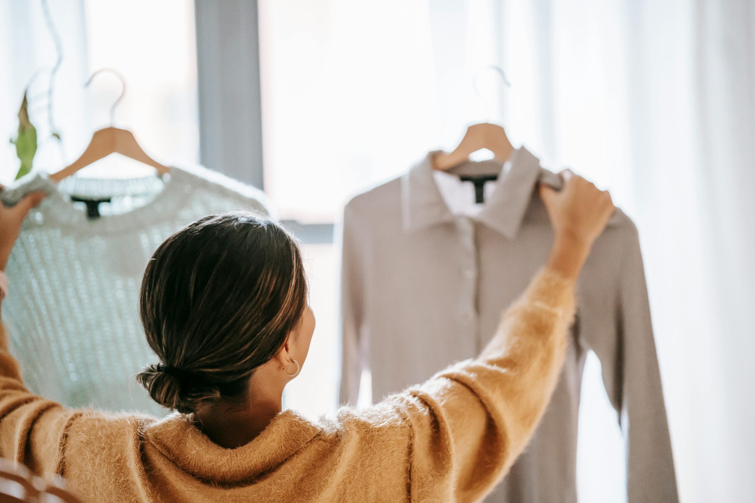woman looking at clothes on a hanger