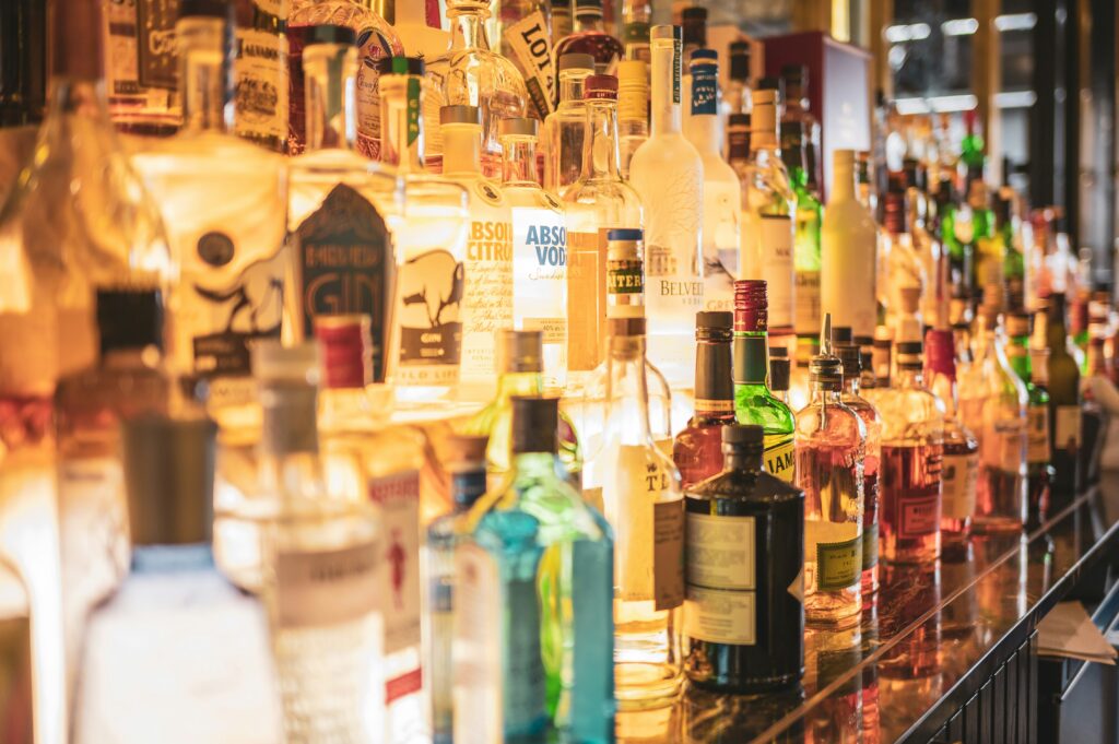 Pineapple Upside-Down Cake Shot Recipe pictured: bar full of liquor bottles